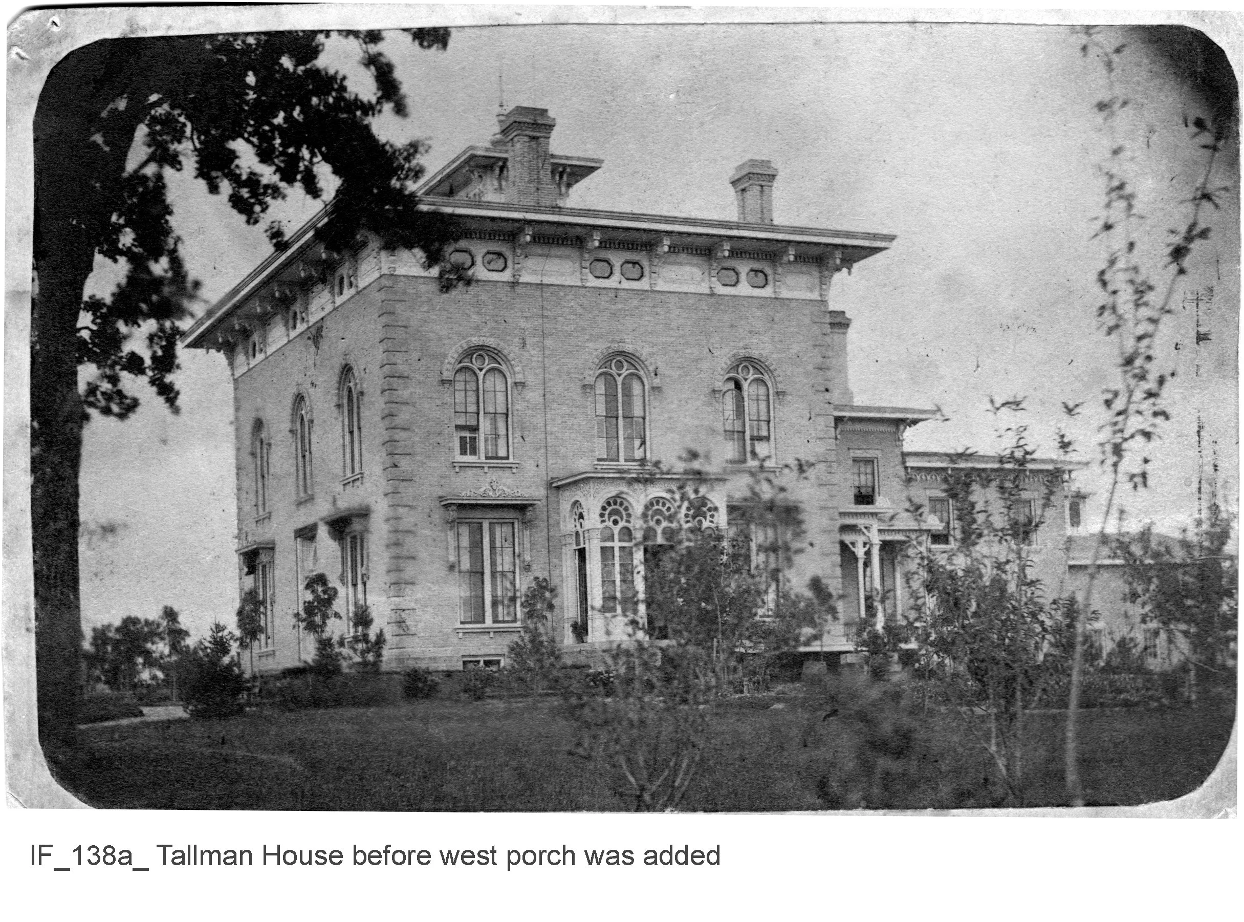 Black and white historic photograph of Tallman House showing its architecture, possibly from the late 19th or early 20th century, surrounded by trees and a garden in front.