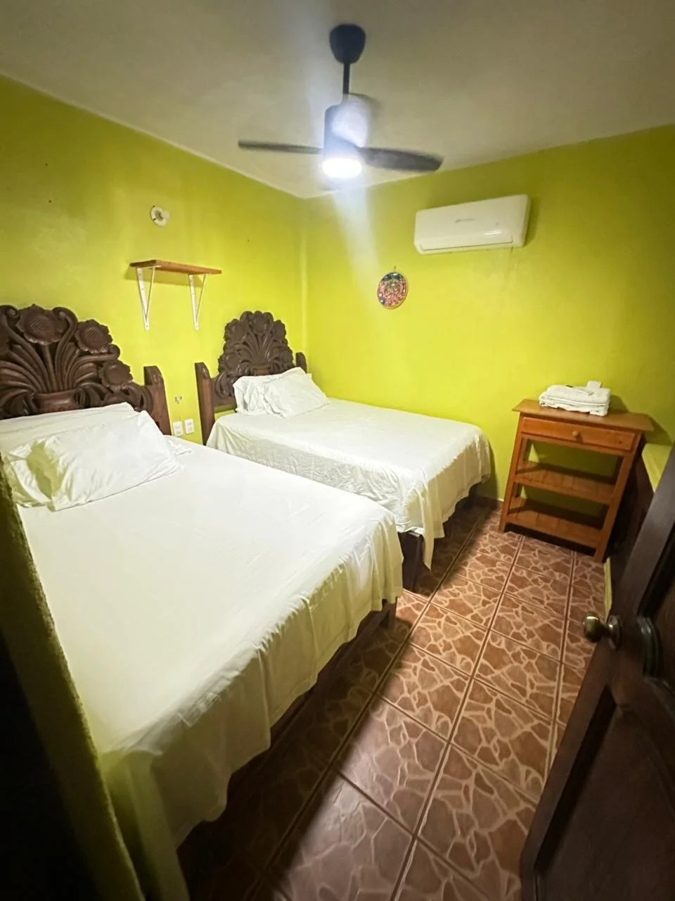 Bedroom with two double beds, a ceiling fan and an air conditioner
