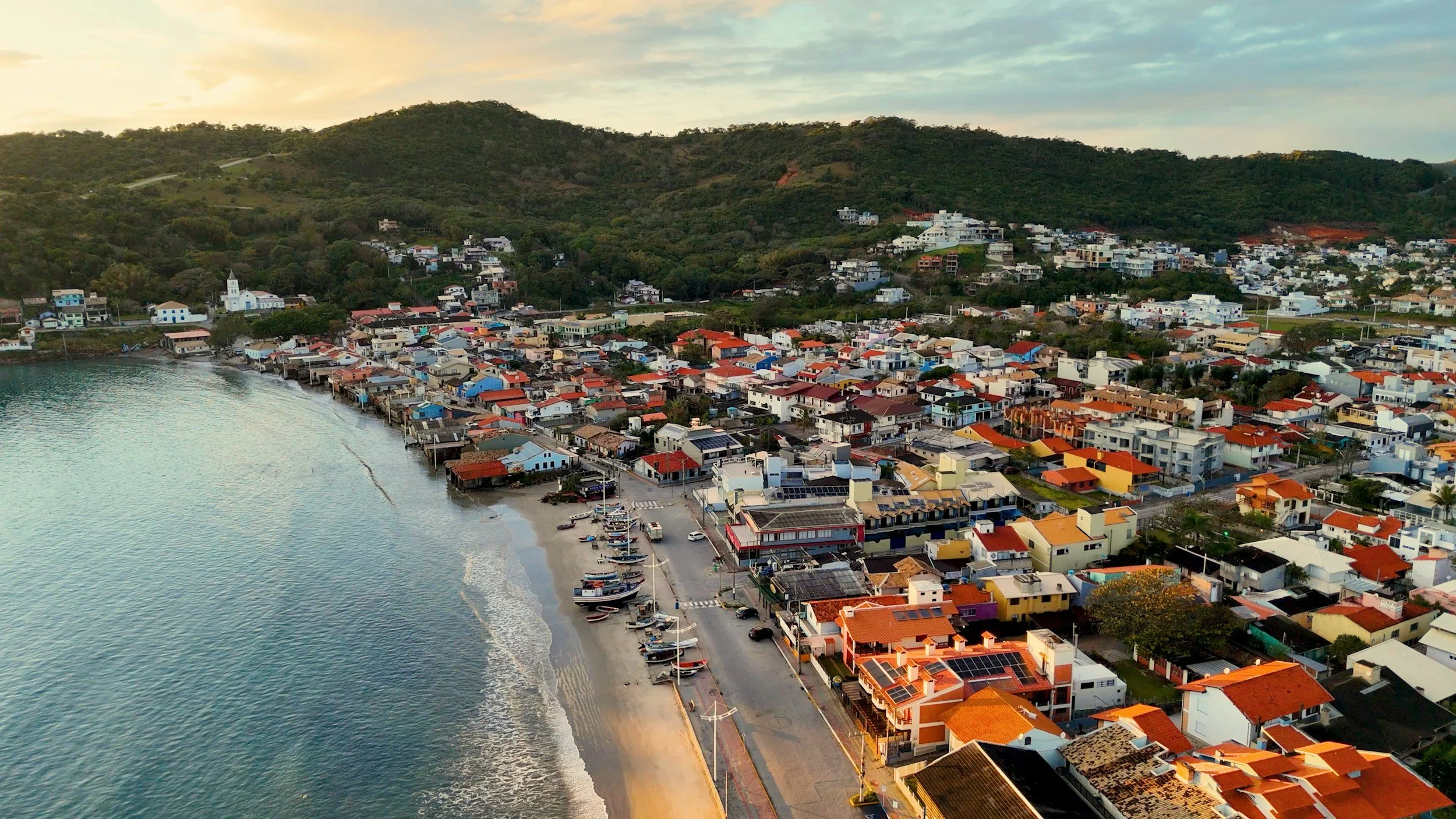 Aerial view of Sayulita, Mexico, with colorful rooftops beside the beach and green hills