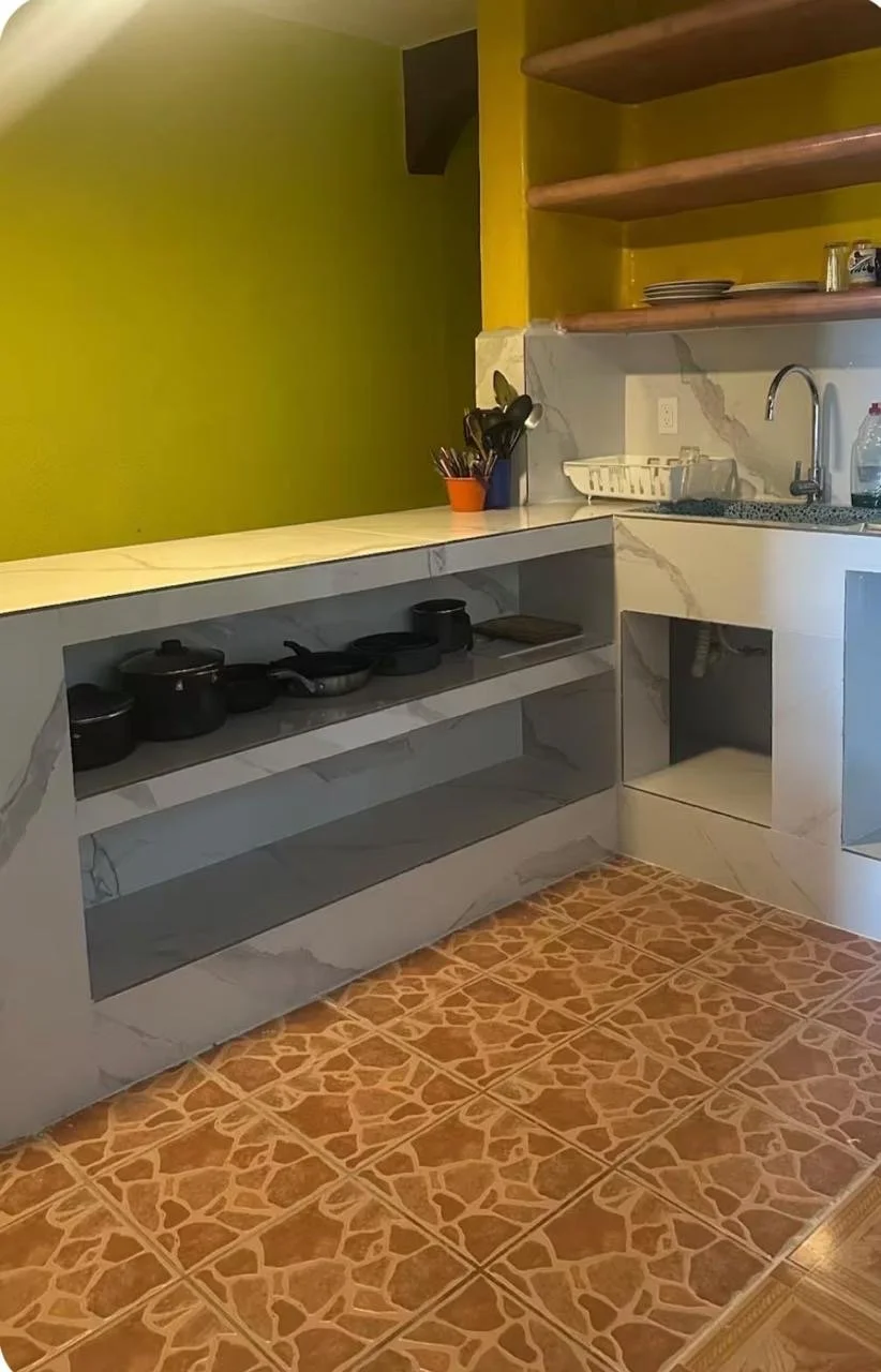 Apartment kitchen with tiled floor, open shelving and a sink