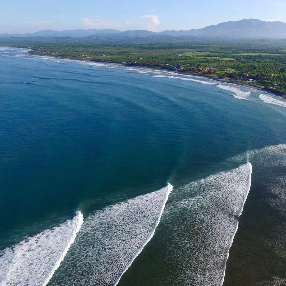 Aerial view of long waves peeling along the La Saladita coastline