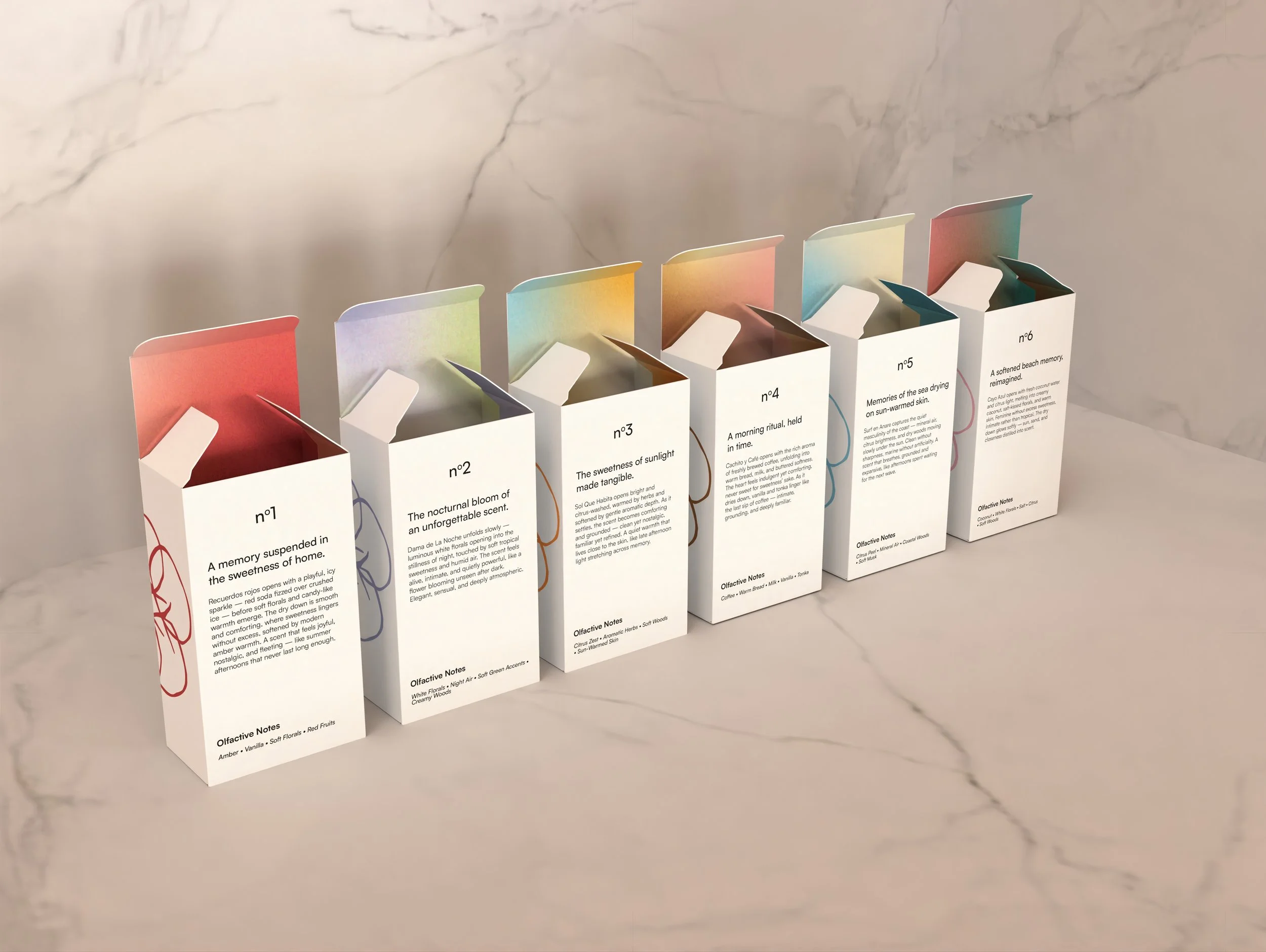 A row of small open white tuck-end boxes arranged on a marble countertop, each with colorful, pastel-colored interiors and minimalist black text describing different scents of the product inside.