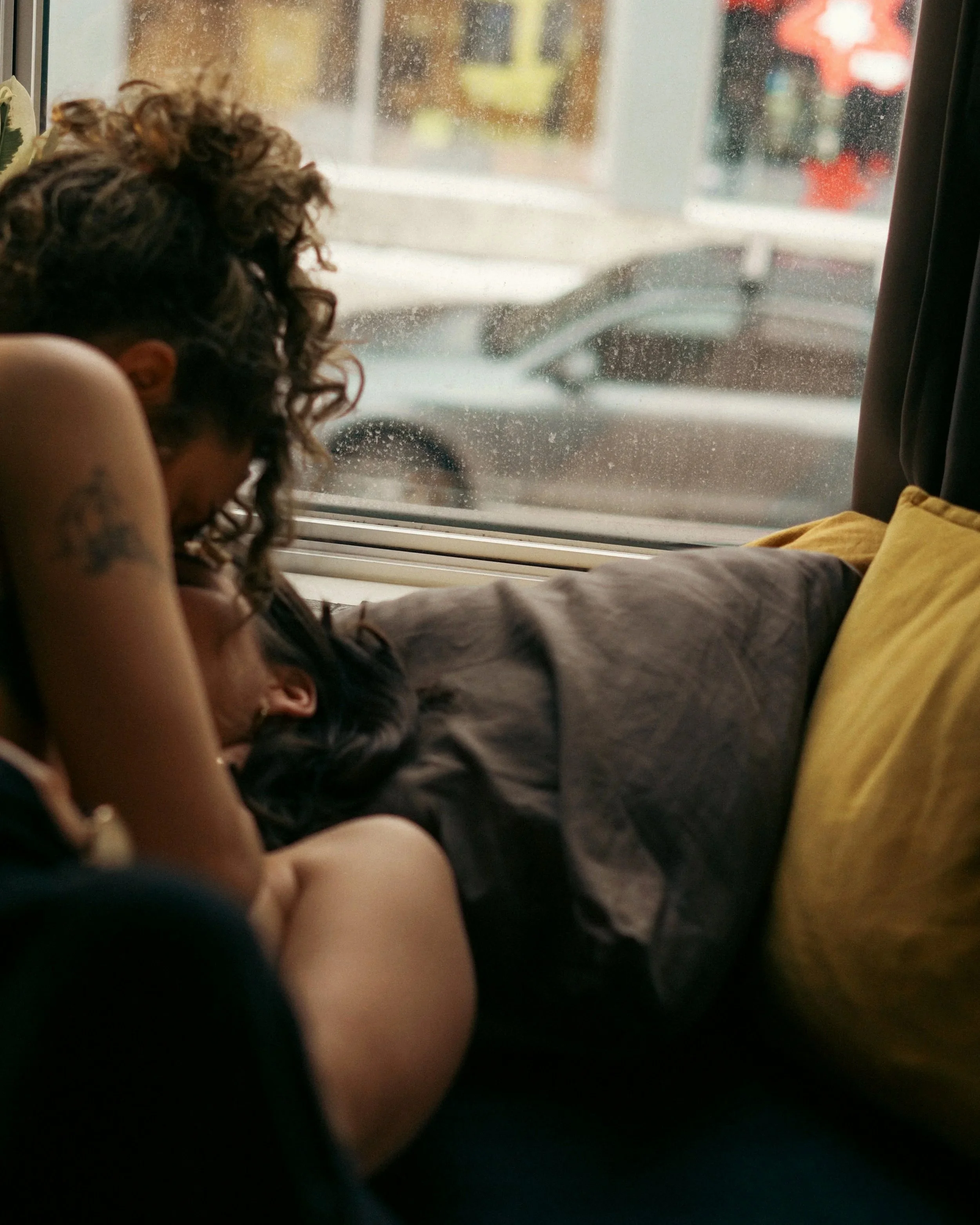 Personne assise dans le bus regardant par la fenêtre, avec une masse de cheveux bouclés.