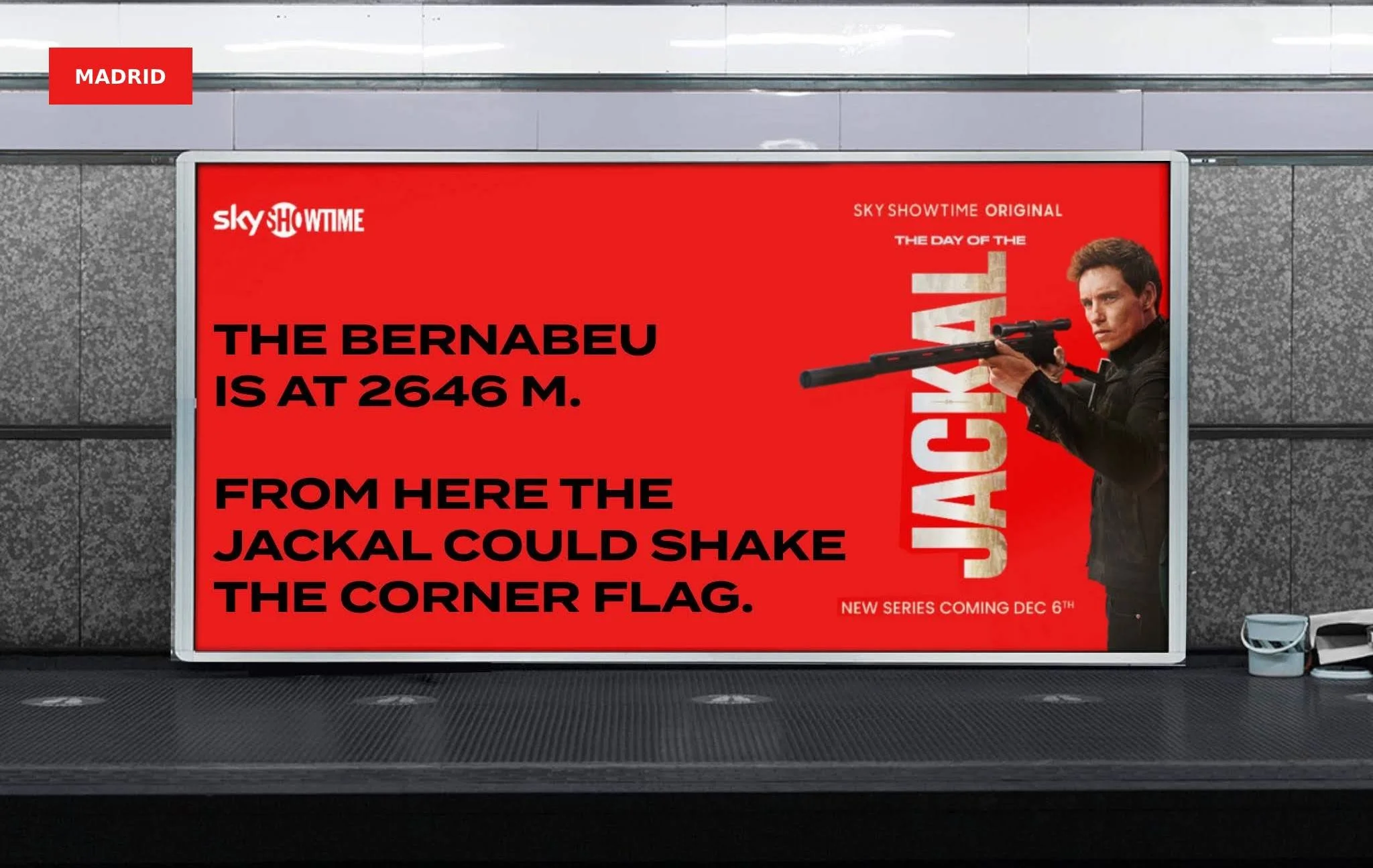 Un anuncio en una parada de autobús que promociona la serie original de Sky ShowTime, mostrando a una persona con un rifle y texto promocional en fondo rojo.