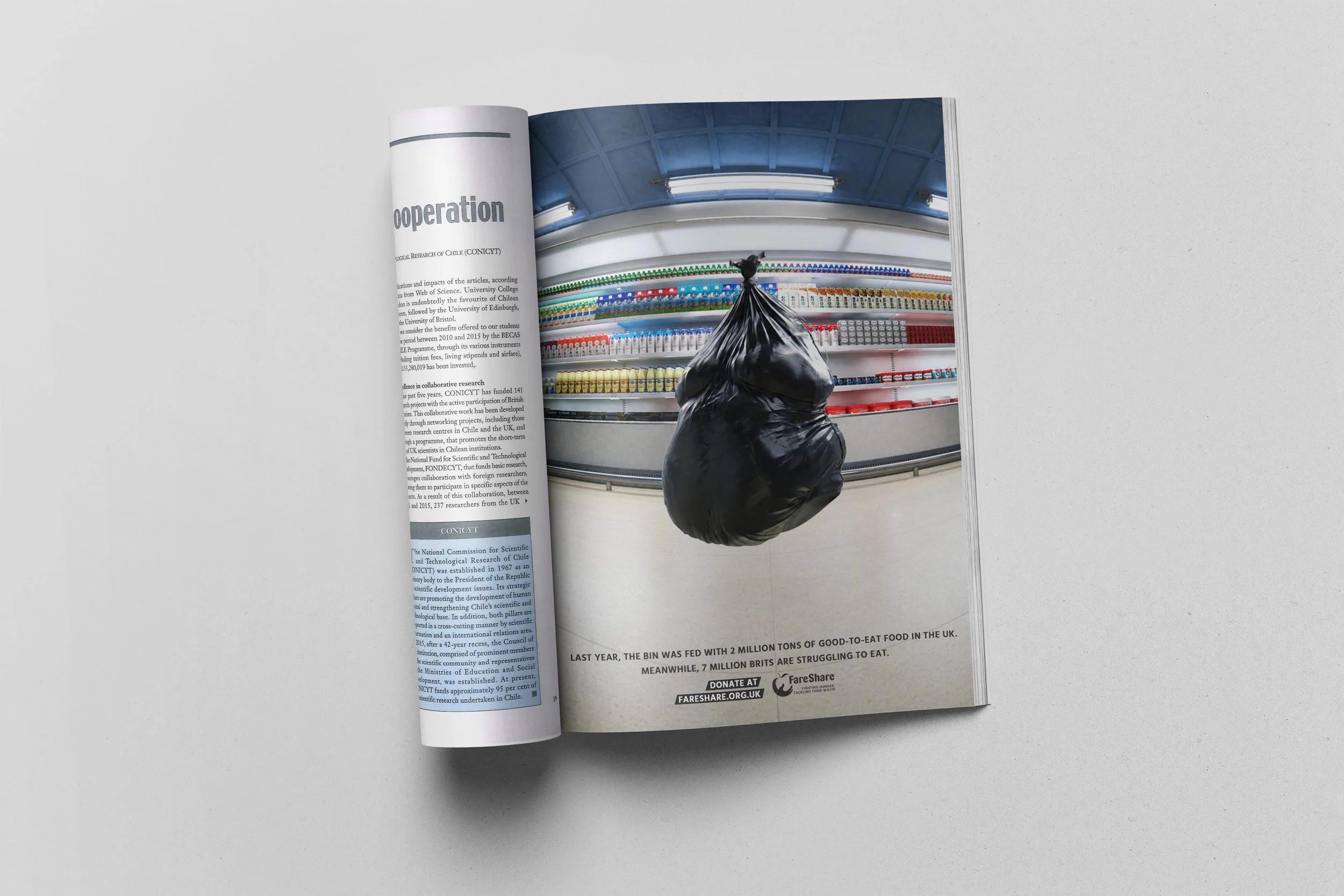 Revista abierta con una página que muestra una fotografía de una máquina expendedora o tintorería y un saco negro colgado, con texto en inglés y un logotipo de organización benéfica en la parte inferior.