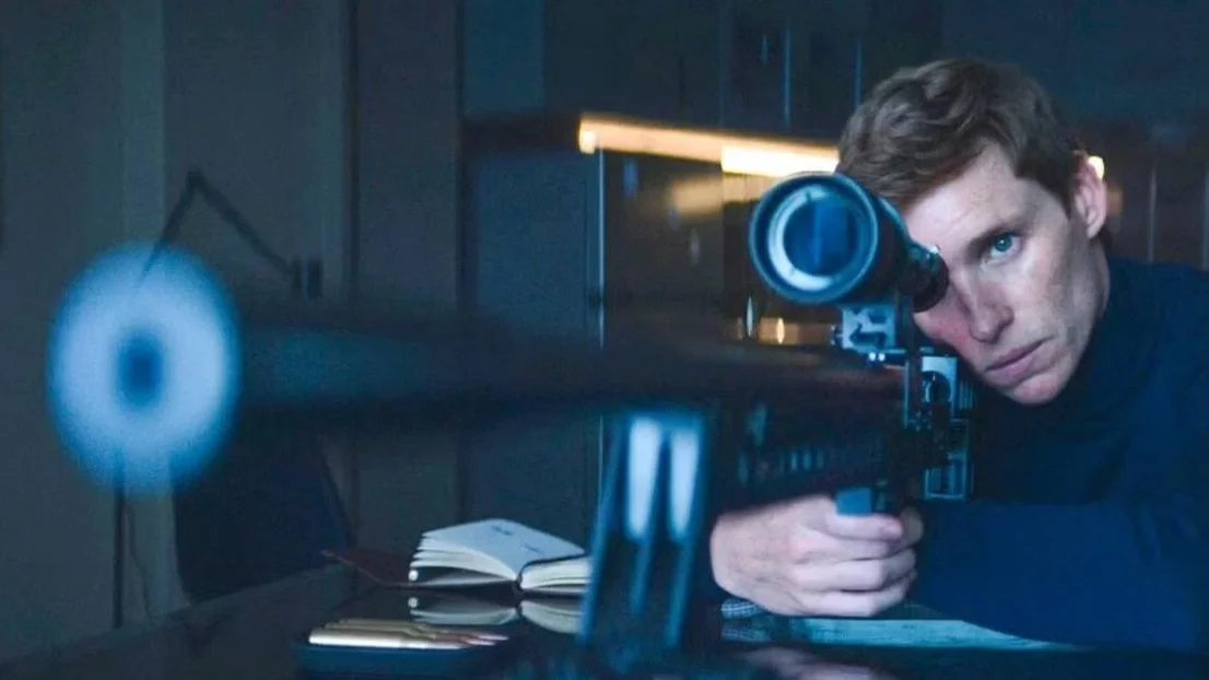 Hombre con rifle de mira telescópica en un entorno oscuro, apuntando con atención