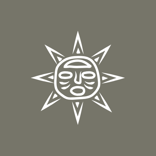 A white tribal mask with a sunburst pattern on a gray background.