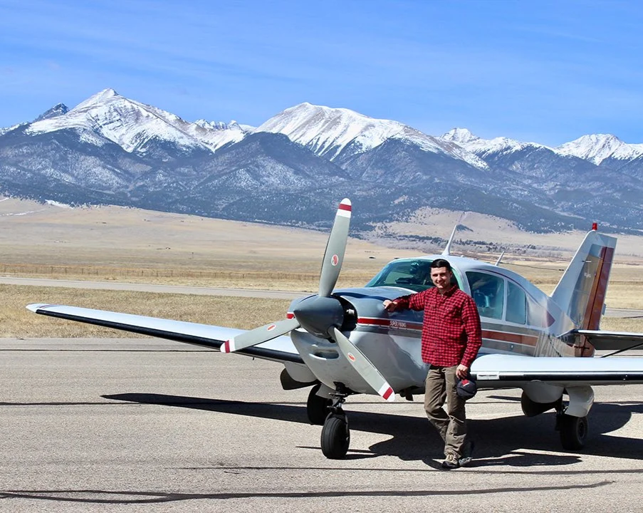 Instructor standing in front of a Bellanca Super Viking airplane