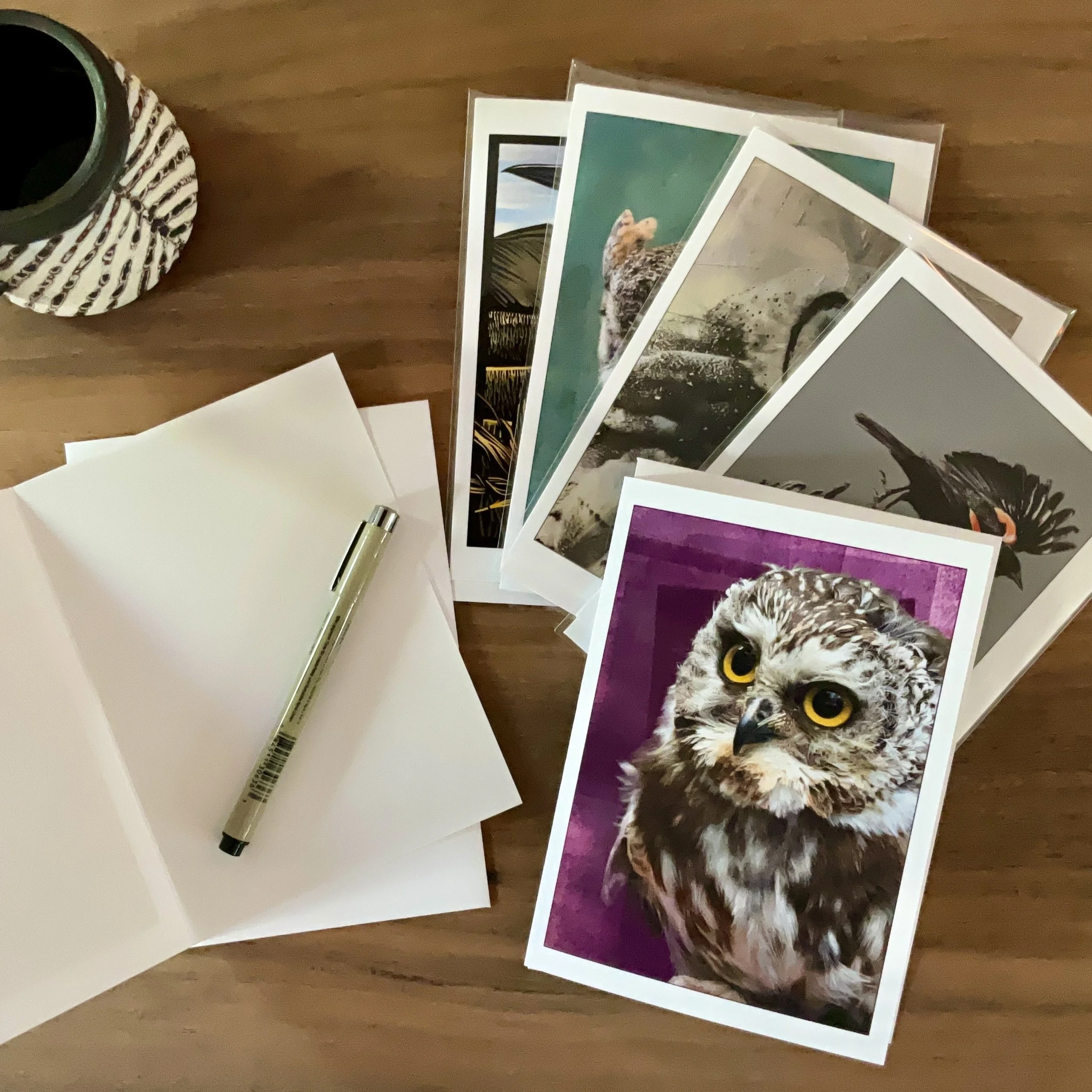 Several of Michelle's card designs displayed on a desk surface, with one card open waiting for a message to be written.