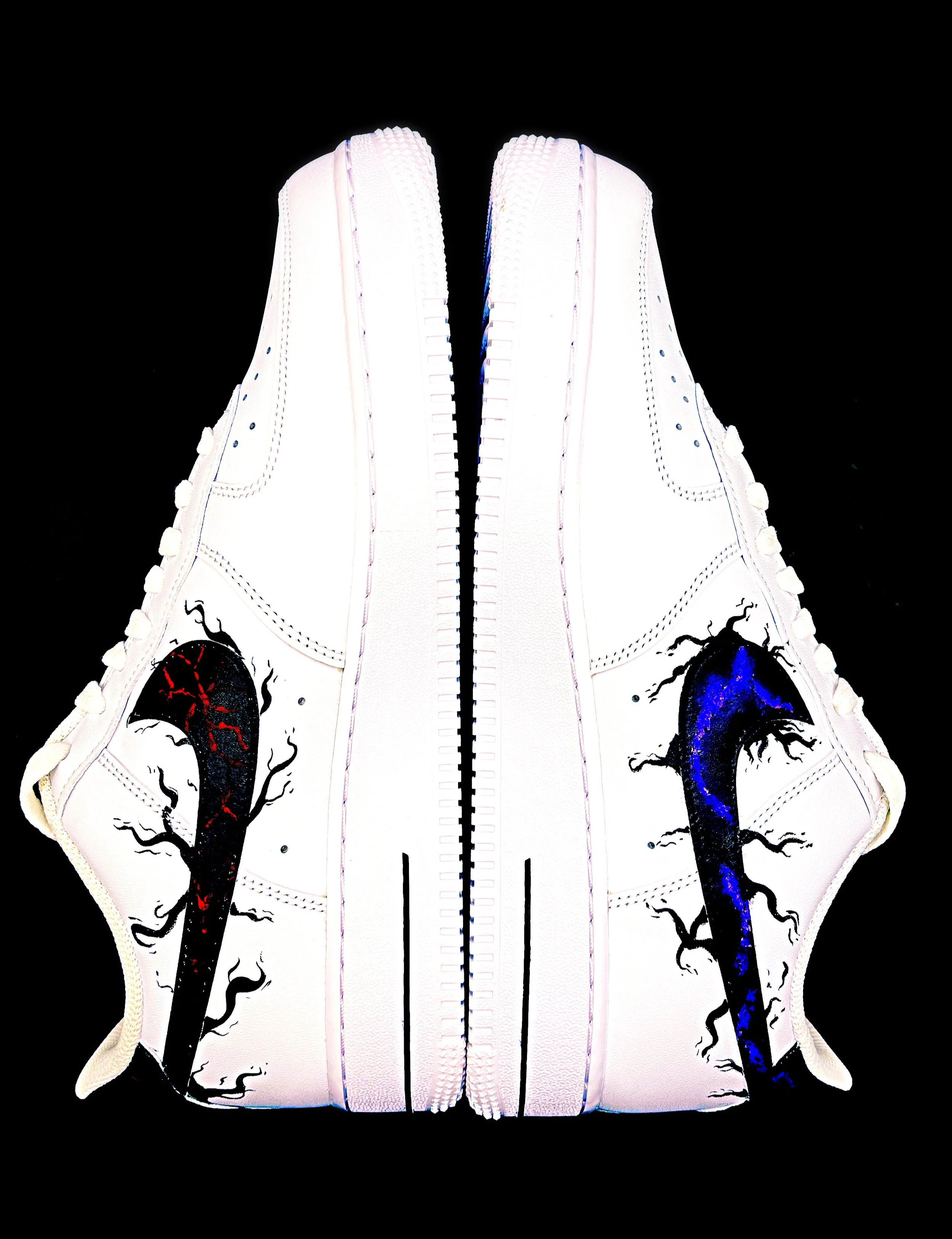 A pair of white Yeezy sneakers with black and red dragon illustrations on the sides, positioned against a black background.