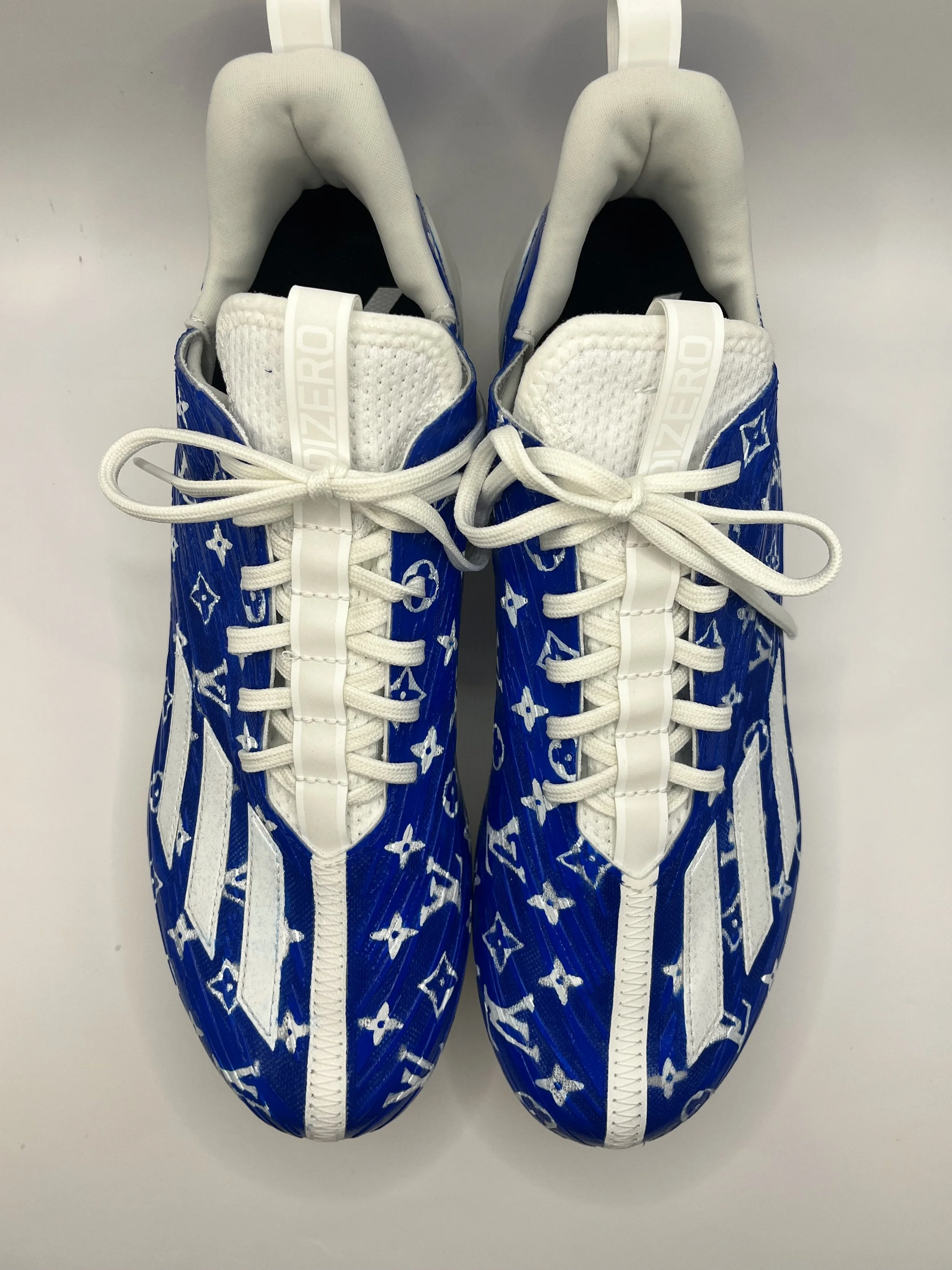 Pair of sneakers with a blue and white pattern, white zippers and laces, and white tongue, positioned side by side on a white surface.