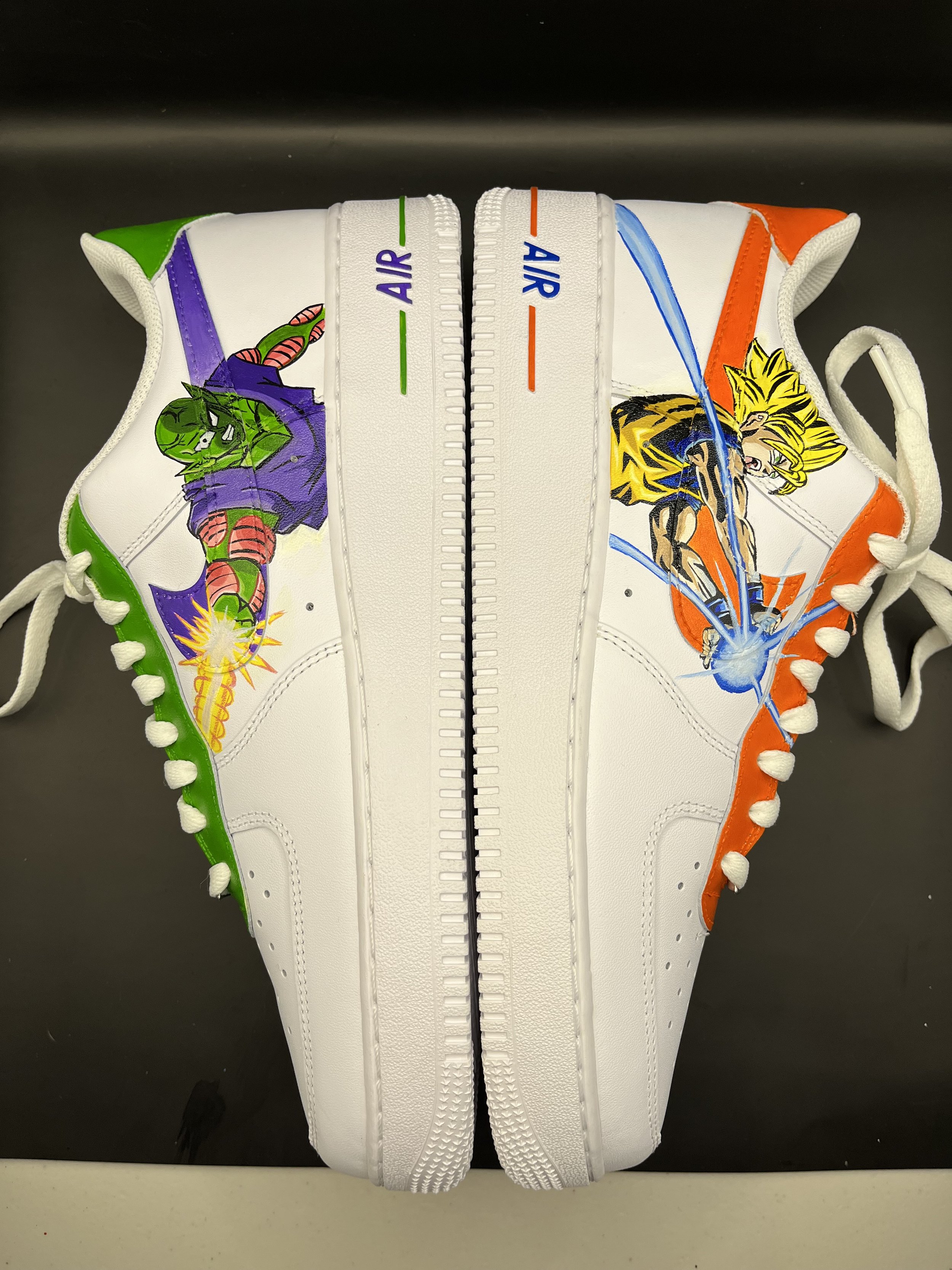Pair of custom artistic Nike sneakers with comic book character designs. The left shoe features a green character with purple background, while the right shoe depicts a yellow-haired character with orange background.