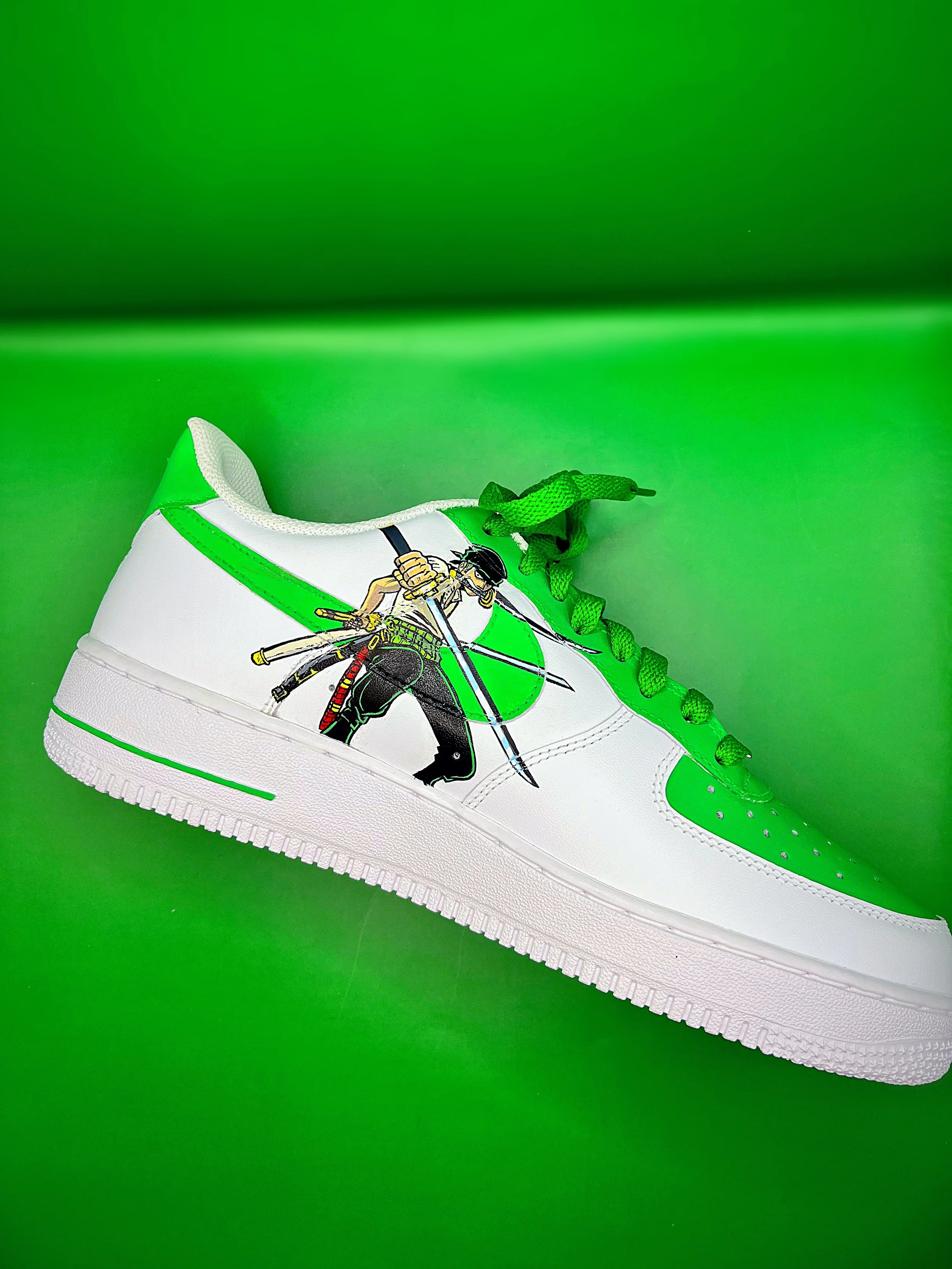 A white sneaker with green accents and laces, featuring a cartoon cyclist graphic on the side, set against a bright green background.