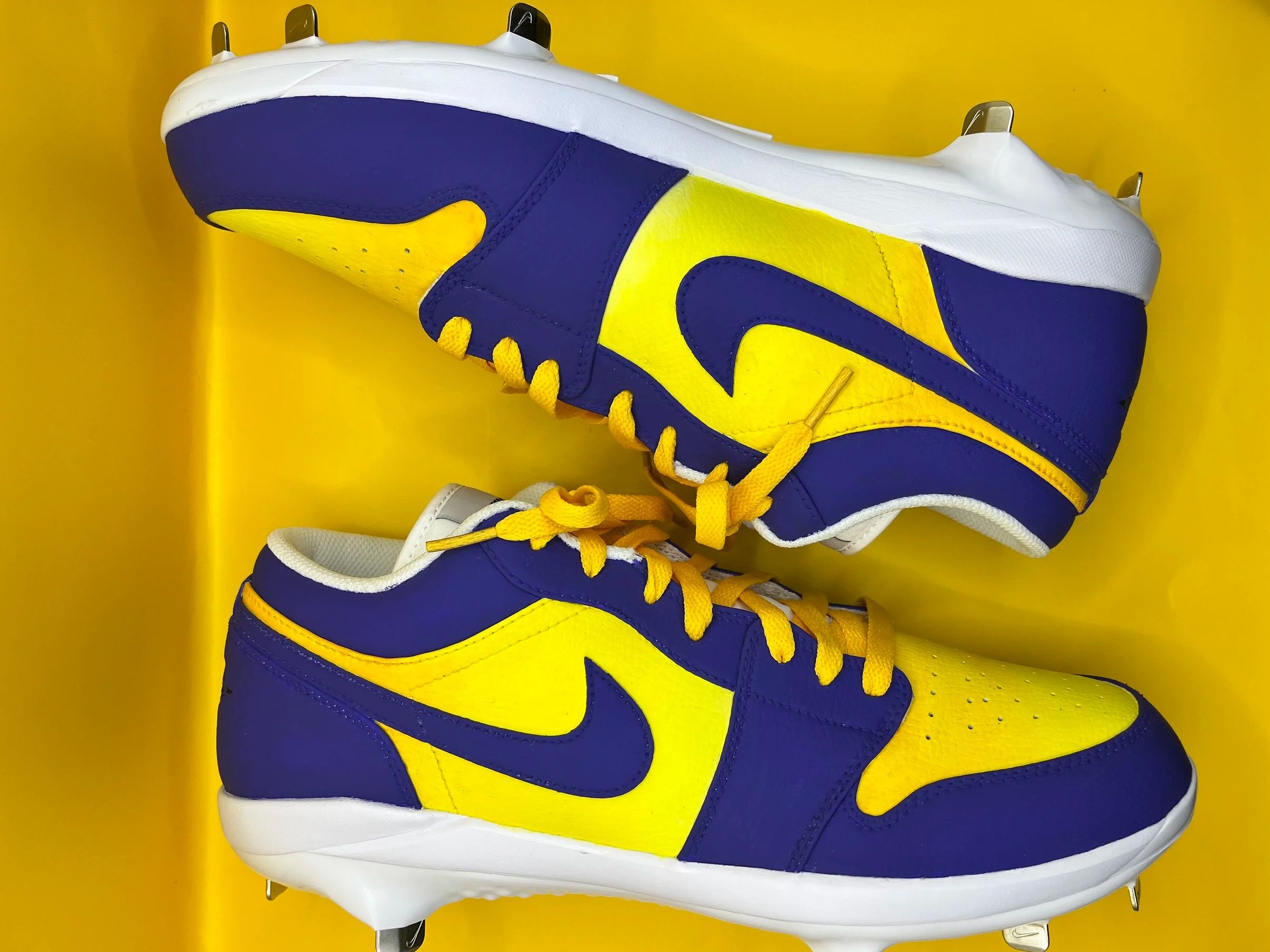 Close-up of a high-top sneaker with a yellow and blue color scheme and yellow laces, set against a yellow background.
