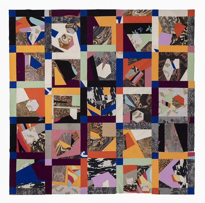 image of a handmade quilt featuring numerous multi-color panels, patterns, and textures