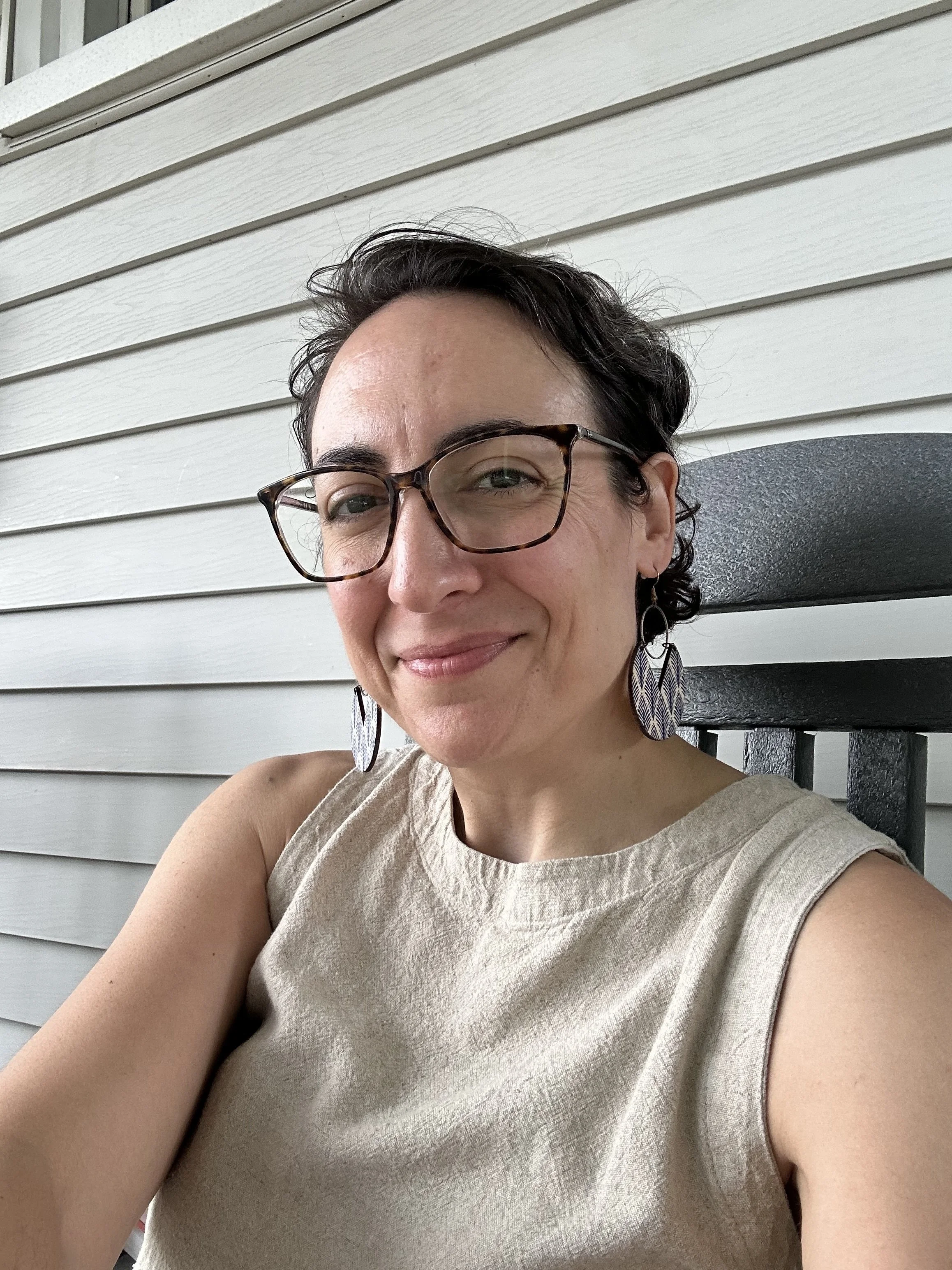 casual selfie of bookstore owner Laura, who is dark-haired and wearing glasses and dangly earrings.