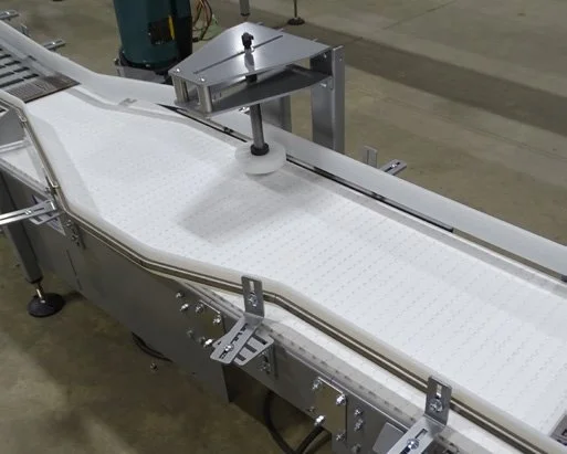 Bump turner rotating a case on a white conveyor belt