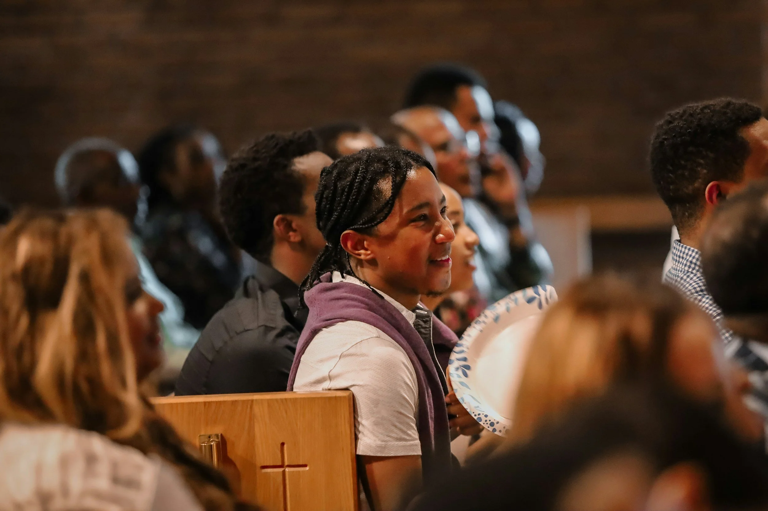Faith community members gathered in a North Carolina church listening during a community meeting