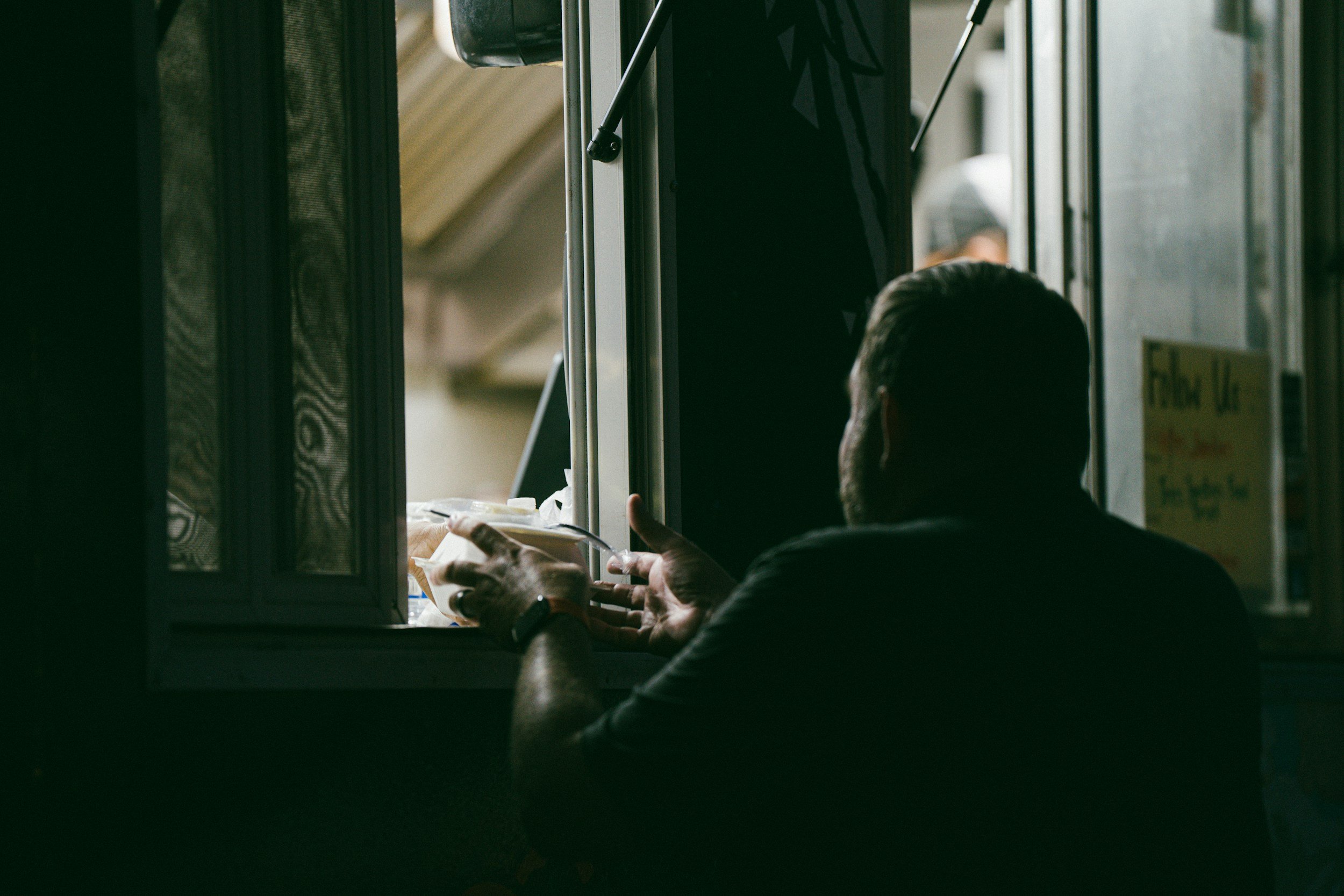 Person speaking through a window during an everyday interaction in North Carolina