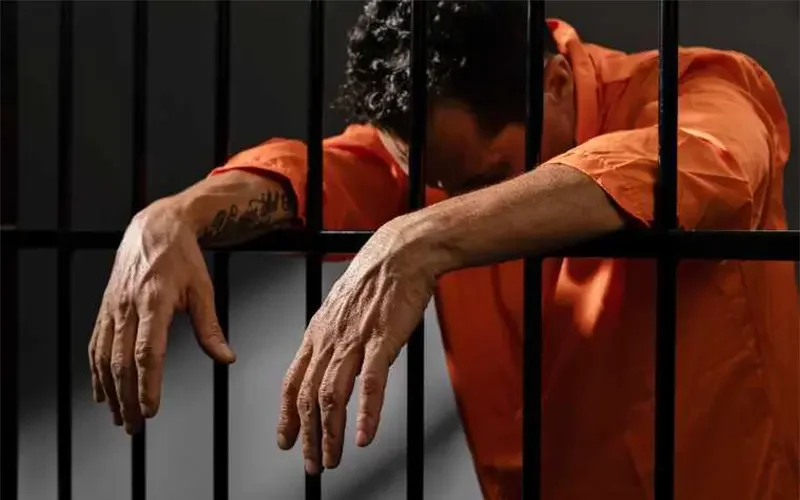 Person behind jail bars representing pretrial detention for those who cannot afford bail