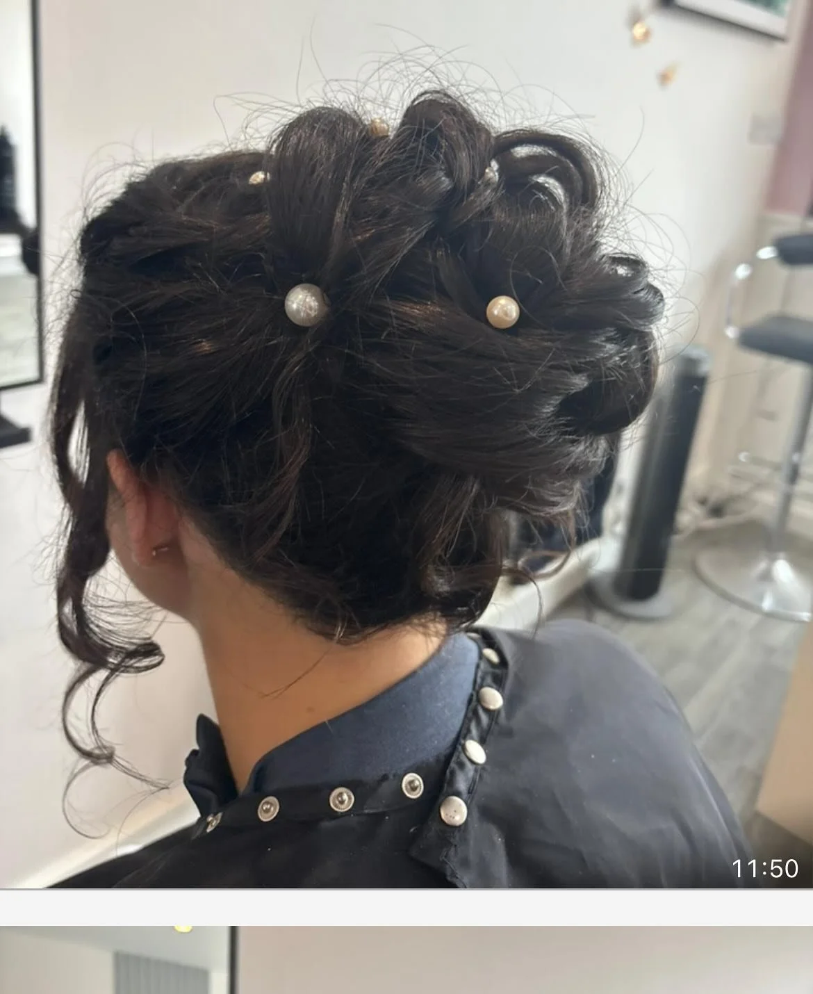 Updo hairstyle with pearl hair accessories and curls, worn by a woman in a salon. Lisa B Hair & Beauty Salon, Carlisle, Cumbria UK.