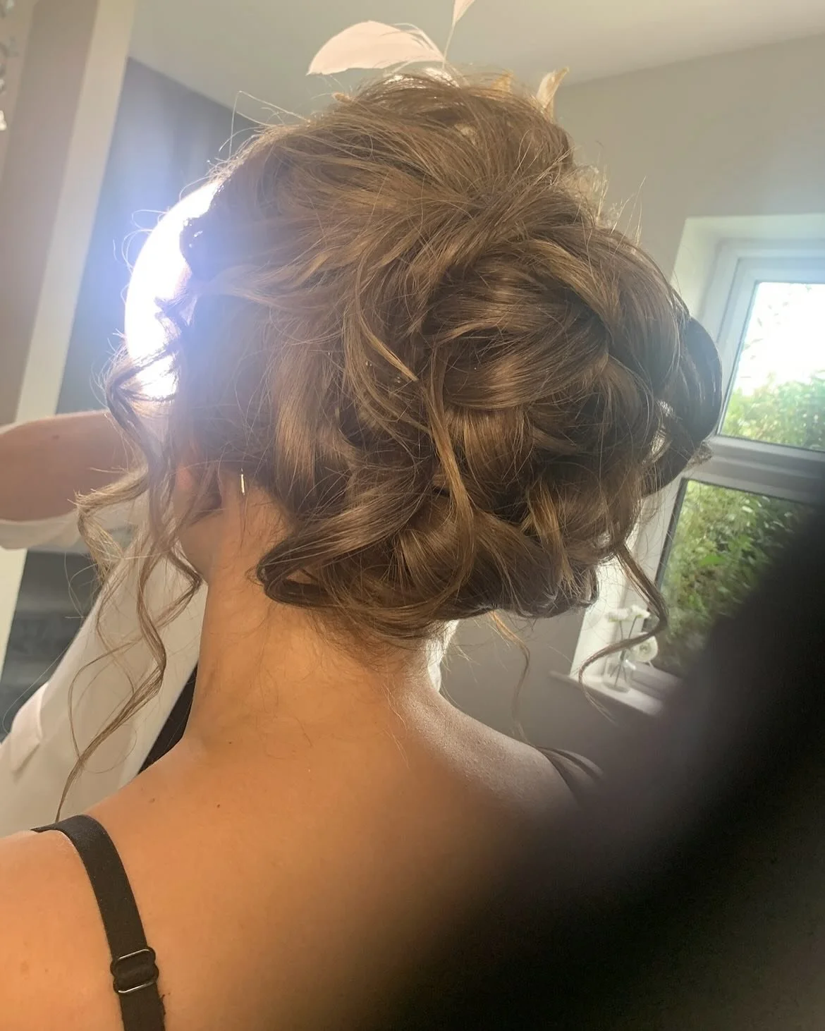 Back view of a woman with brown, curly updo hairstyle, at Lisa B Hair & Beauty Salon, Carlisle, Cumbria UK.