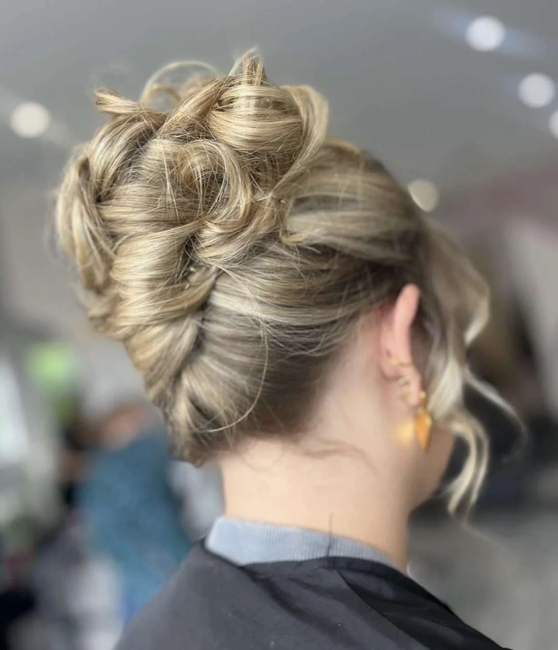 Back of a woman with a short hairstyle, styled in elegant, voluminous curls.