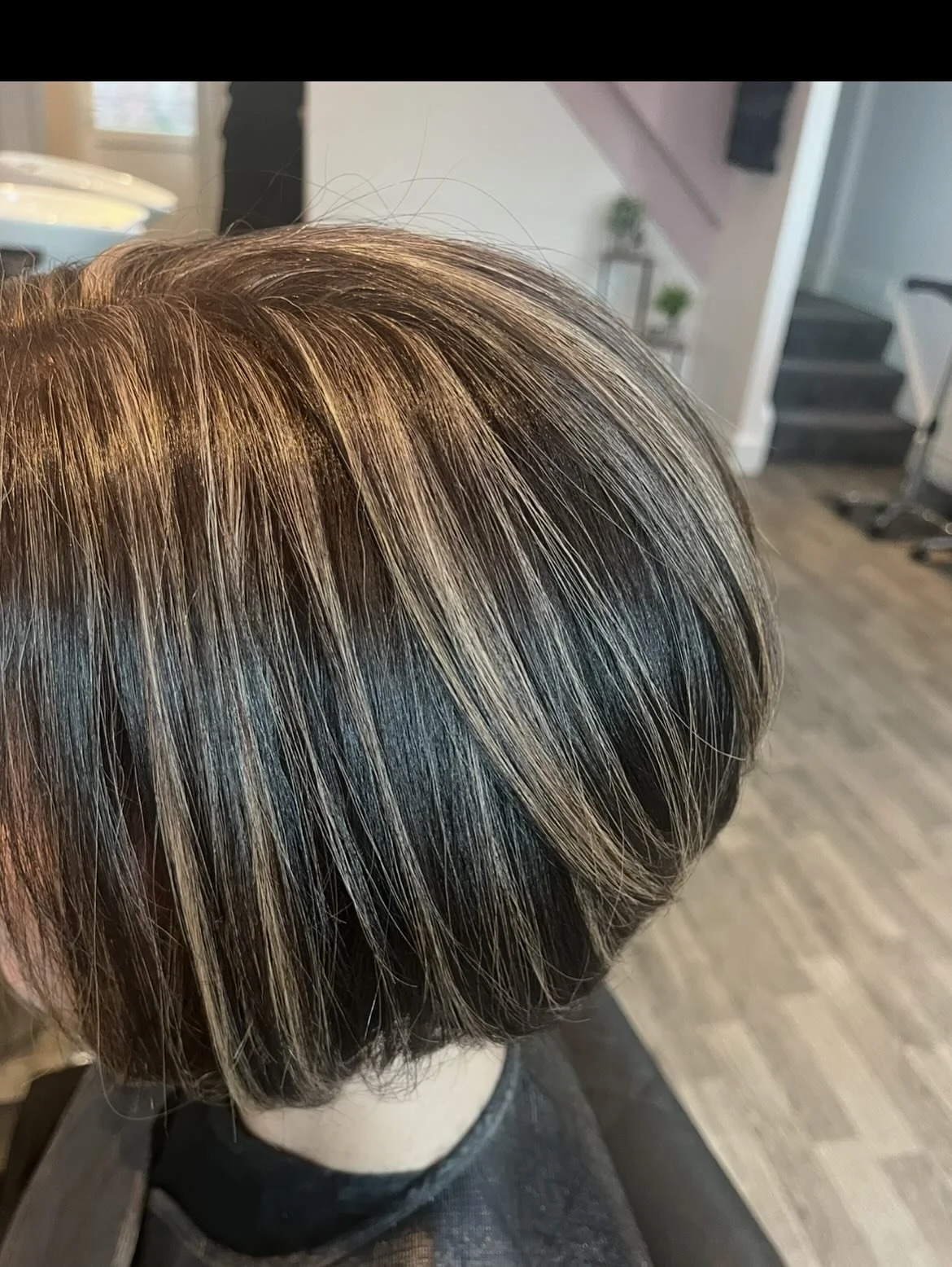 Close-up of a person's short haircut with light brown and blonde highlights, taken inside a salon. Lisa B Hair & Beauty Salon, Carlisle, Cumbria UK.