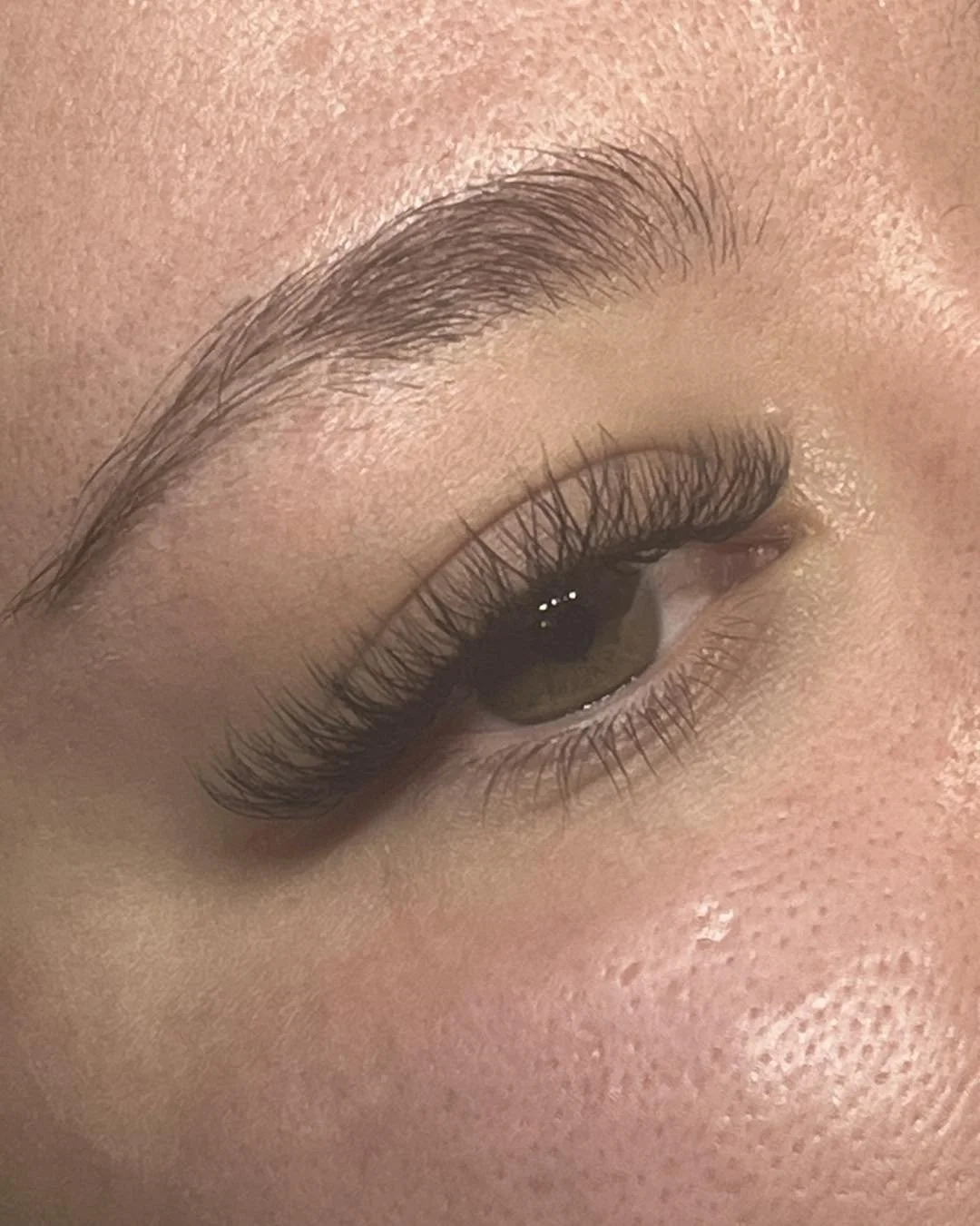 Close-up of a person's eye with natural makeup, showcasing long eyelashes, well-groomed eyebrows. Award winning Lisa B Hair and Beauty Salon in Carlisle, Cumbria UK.