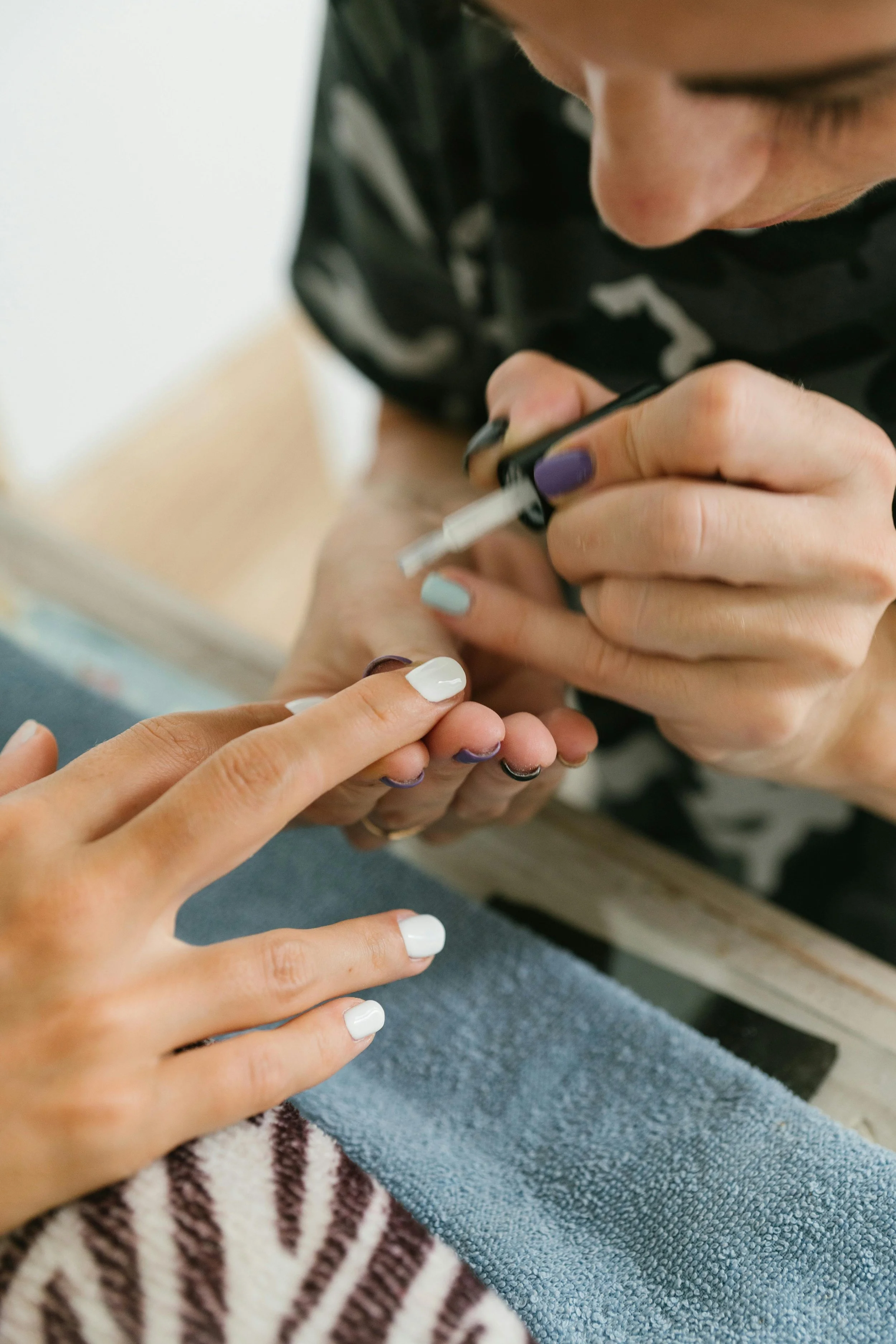 Person receiving a manicure, with someone applying nail polish on their nails. Award winning Lisa B Hair and Beauty Salon in Carlisle, Cumbria UK.