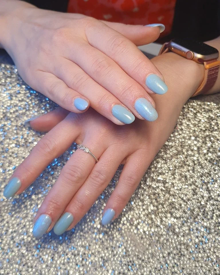 Two hands with manicured nails, one wearing a ring and a smartwatch, resting on a glittery surface. Award winning Lisa B Hair and Beauty Salon in Carlisle, Cumbria UK.