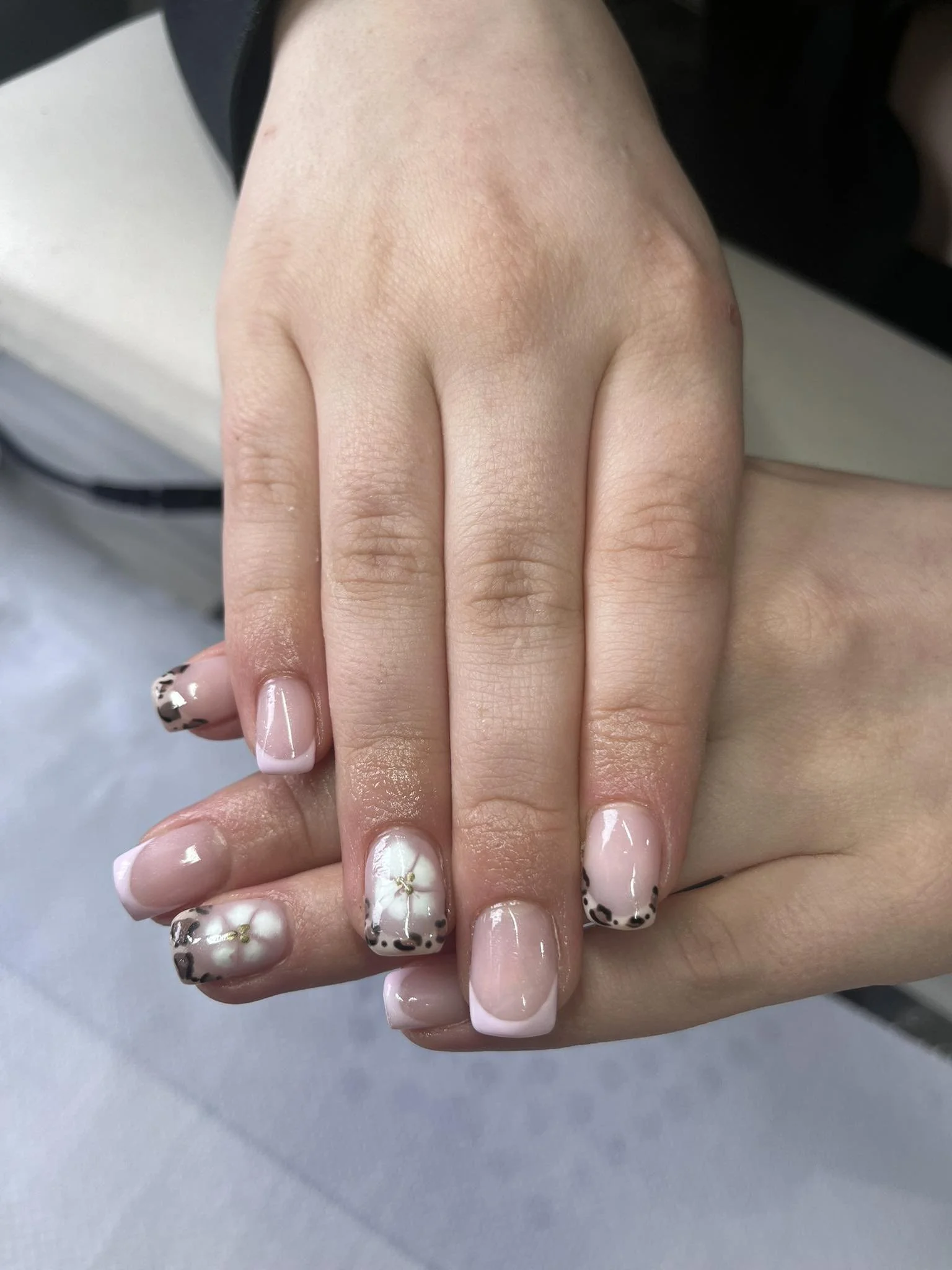 Close-up of a person's hand with well-manicured nails featuring a floral and leopard print design. Award winning Lisa B Hair and Beauty Salon in Carlisle, Cumbria UK.