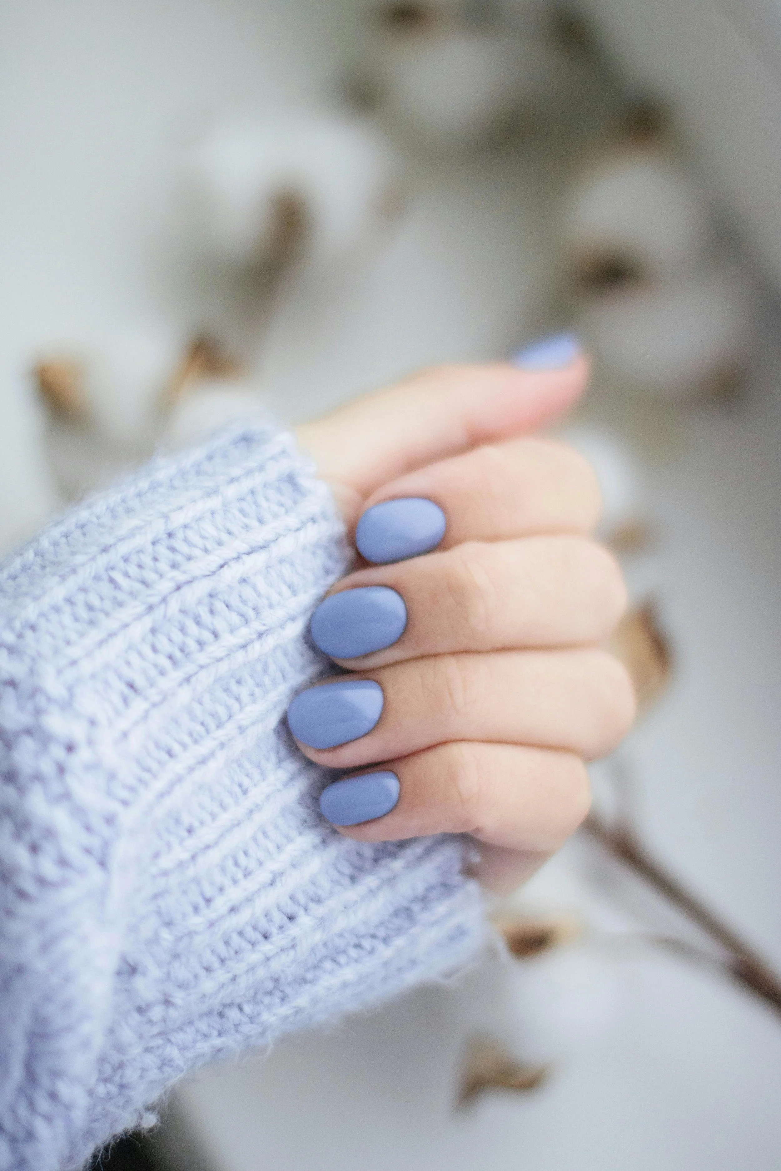 Close-up of two hands clasped together, one with light pink skin and the other with light skin, both with pastel blue nail polish. Award winning Lisa B Hair and Beauty Salon in Carlisle, Cumbria UK.