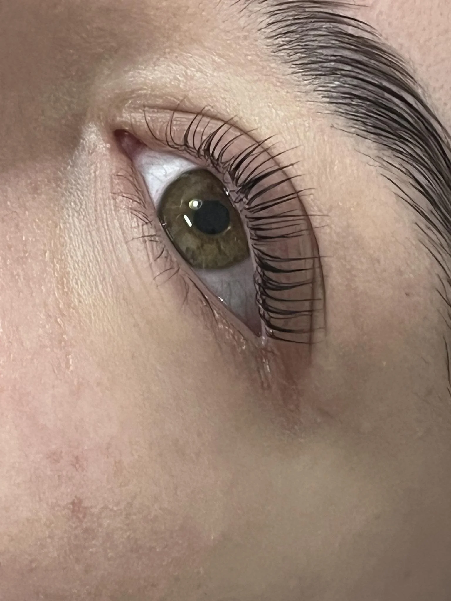 Close-up of a human eye with light brown iris, long eyelashes, and surrounding skin. Award winning Lisa B Hair and Beauty Salon in Carlisle, Cumbria UK.