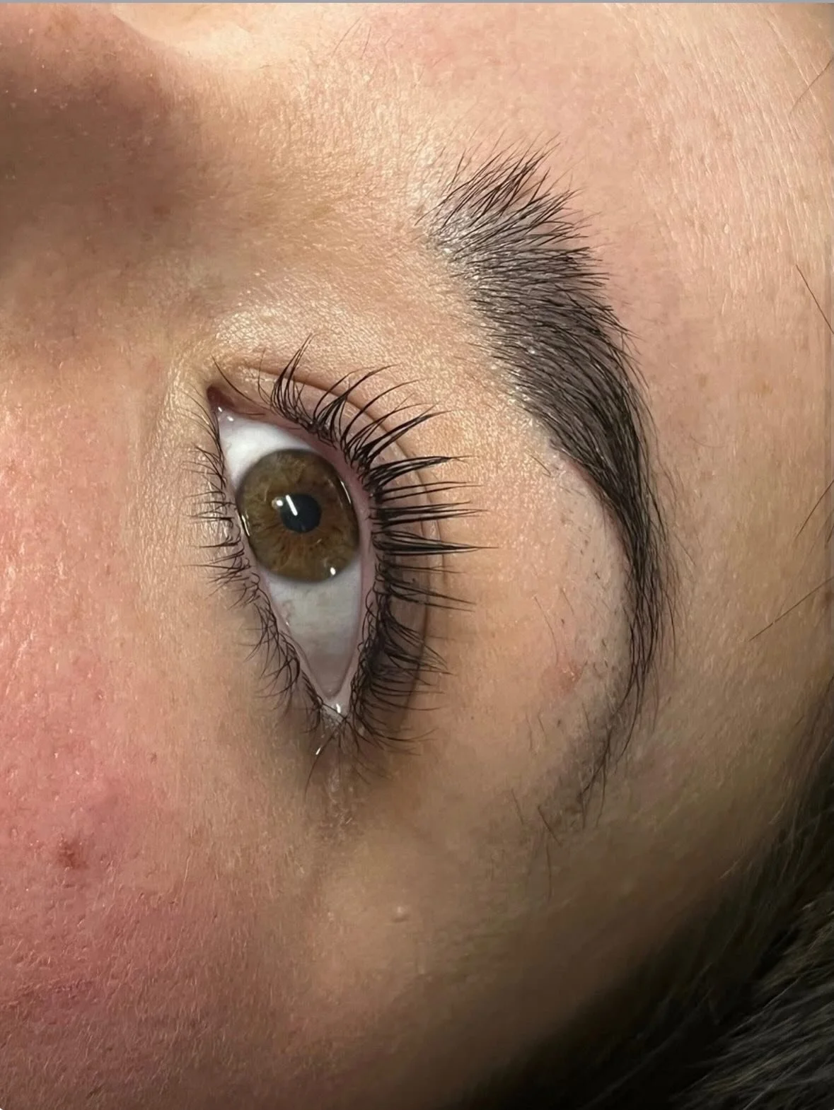 Close-up of a person's eye showing brown iris, long eyelashes, and well-groomed eyebrow. Award winning Lisa B Hair and Beauty Salon in Carlisle, Cumbria UK.