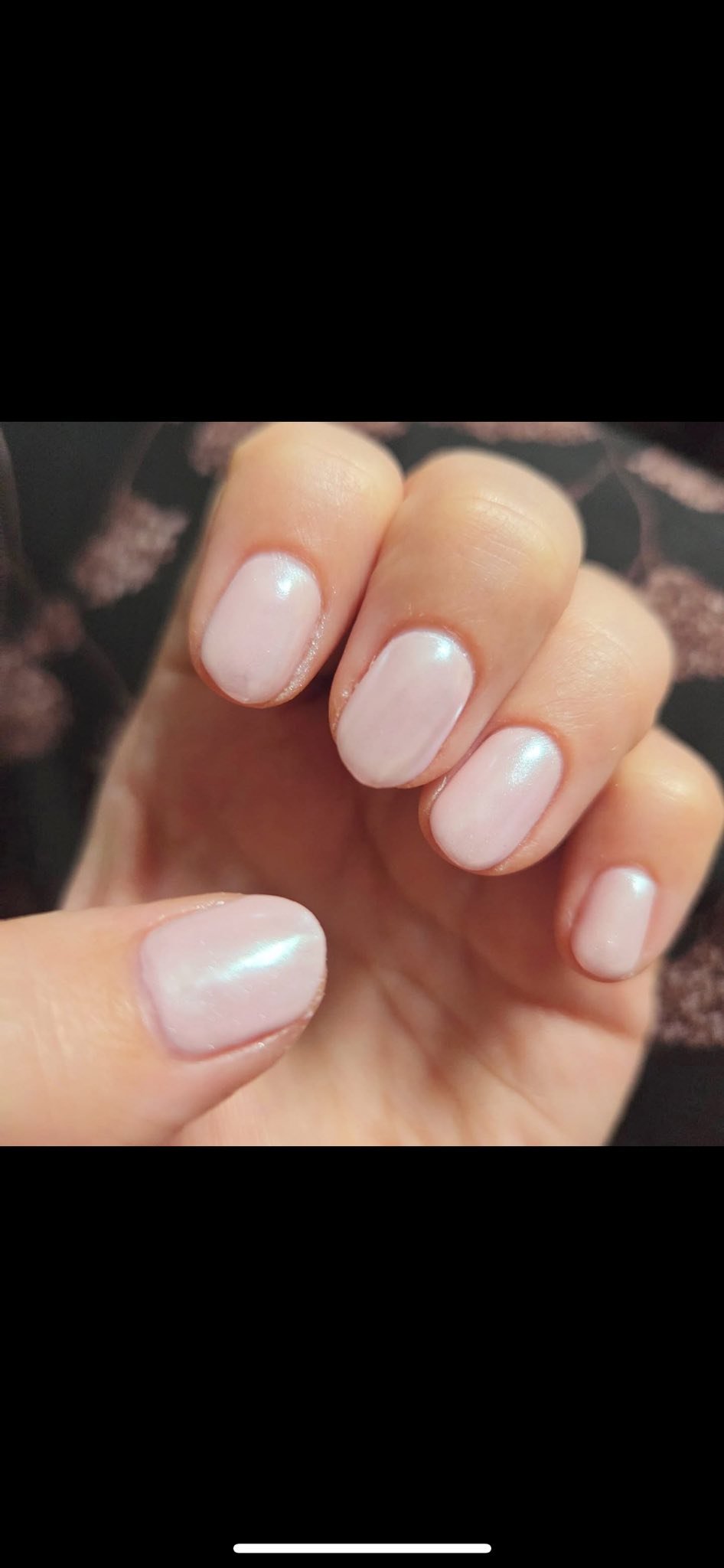 Close-up of a hand with neatly manicured nails painted with a light, iridescent pink nail polish. Award winning Lisa B Hair and Beauty Salon in Carlisle, Cumbria UK.