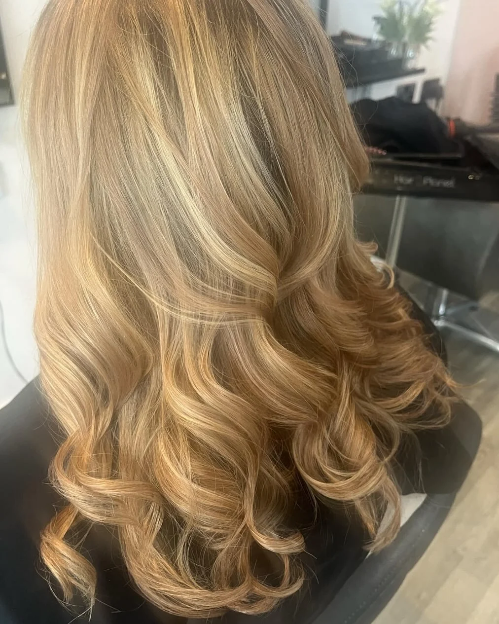 Woman with long, voluminous blonde hair styled in loose curls at Lisa B Hair & Beauty Salon, Carlisle, Cumbria UK.