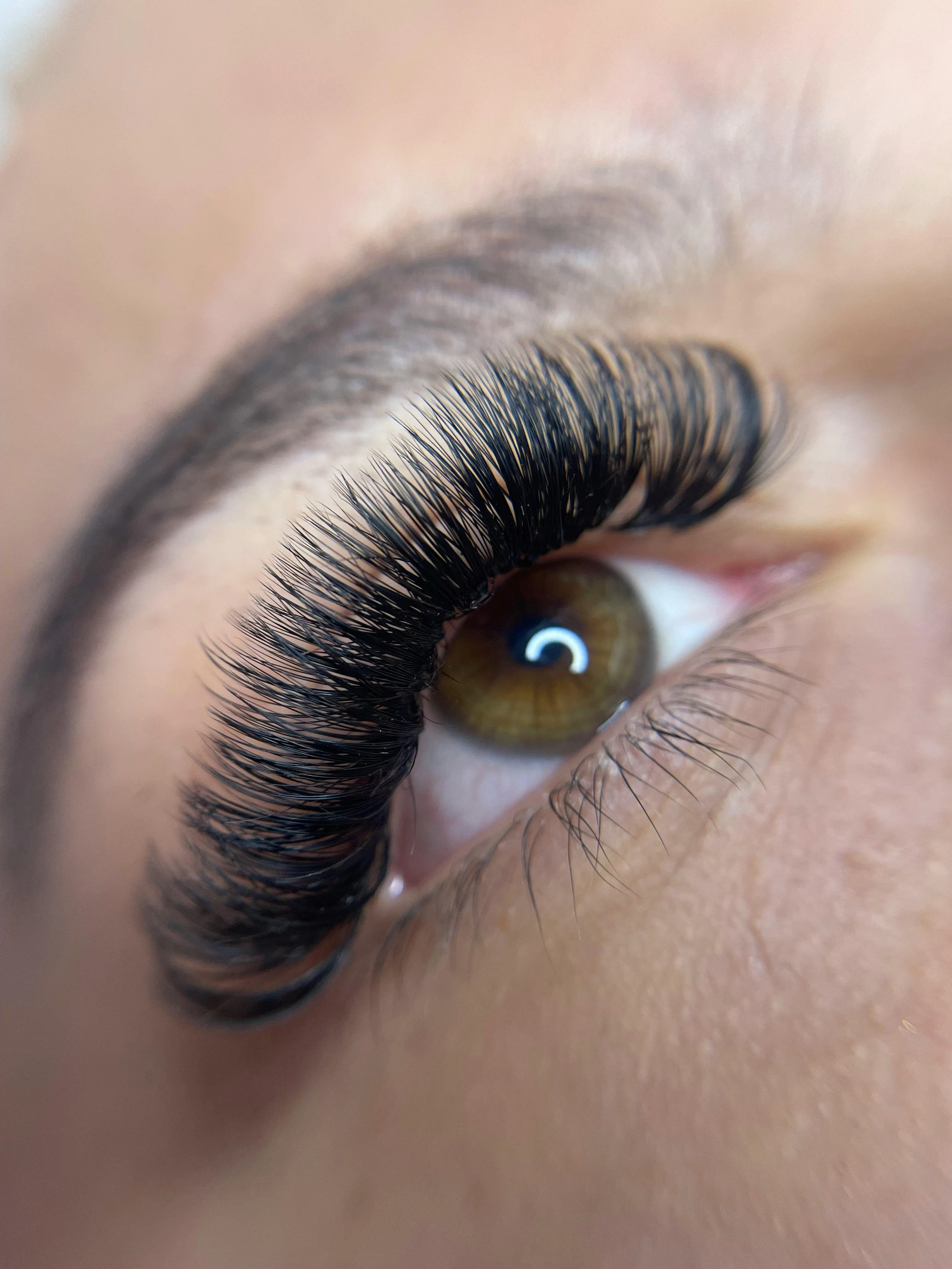 Close-up of a person's eye with long, thick eyelashes and brown iris. Lisa B Hair & Beauty Salon, Carlisle, Cumbria UK.
