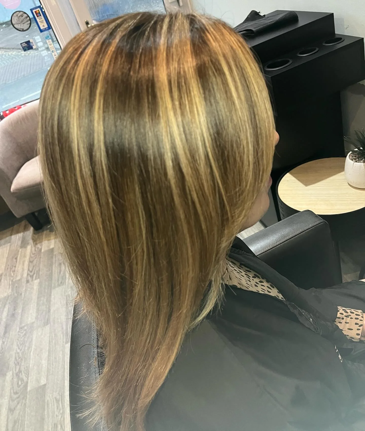 A woman with shoulder-length, blonde hair sitting in a salon or similar setting.