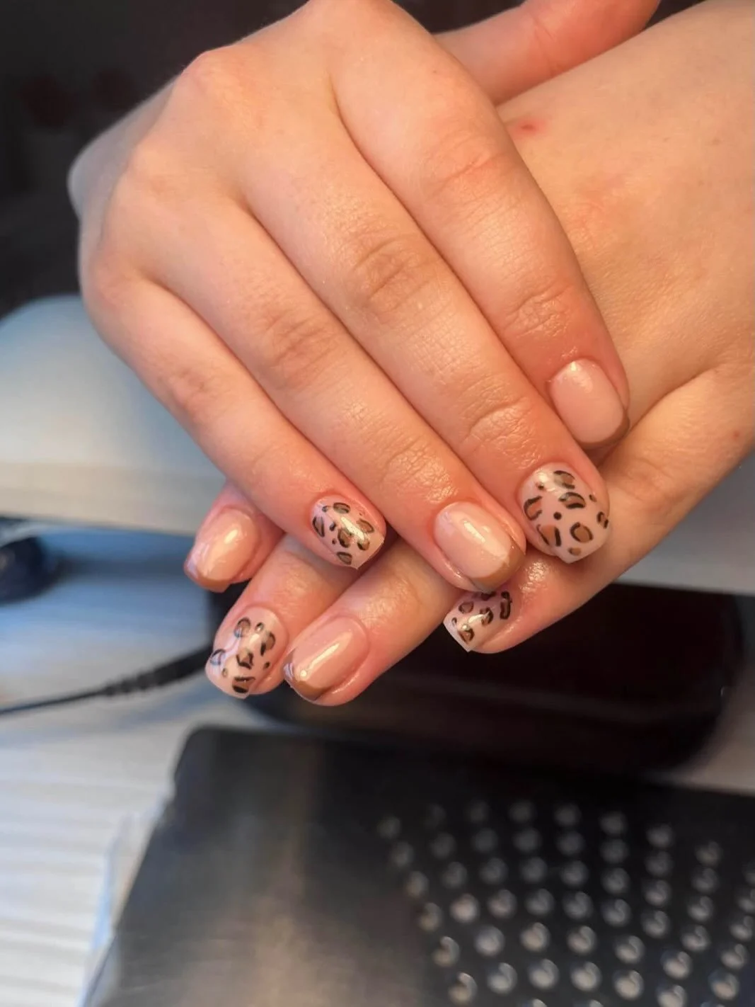 Close-up of hands with beige nails and leopard print design on some nails. Award winning Lisa B Hair and Beauty Salon in Carlisle, Cumbria UK.