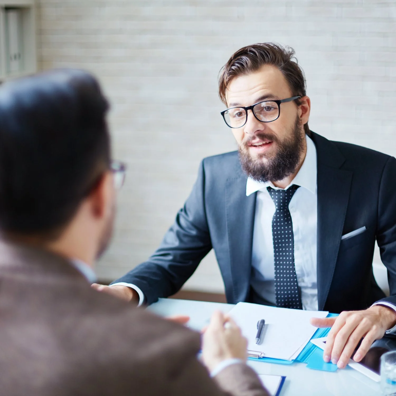 Hiring manager interviewing a job candidate across the desk