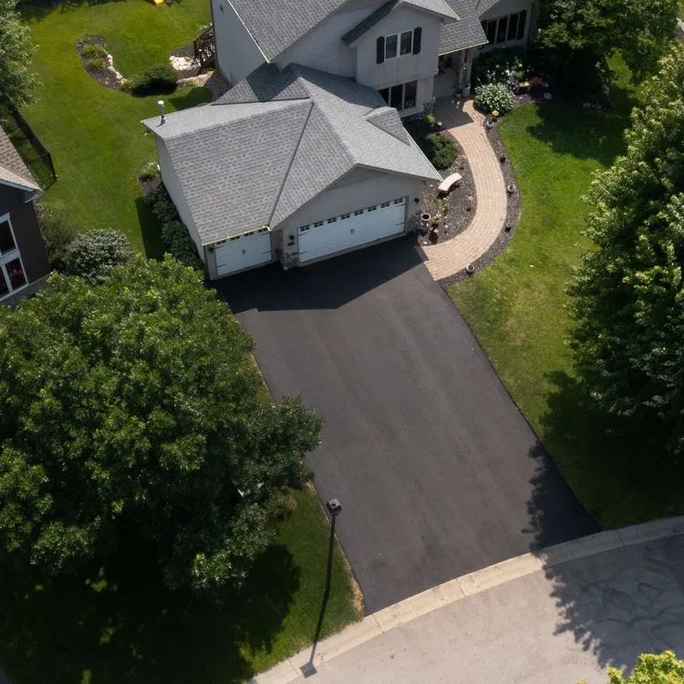 Aerial view of a new asphalt driveway installation at a Twin Cities home