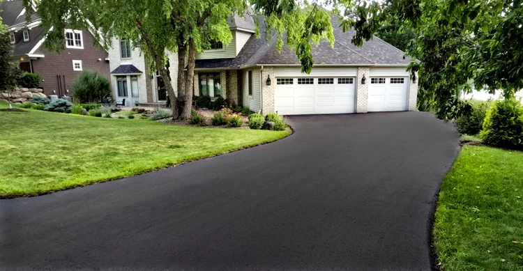 J&W Asphalt crew laying and compacting asphalt on a new residential driveway