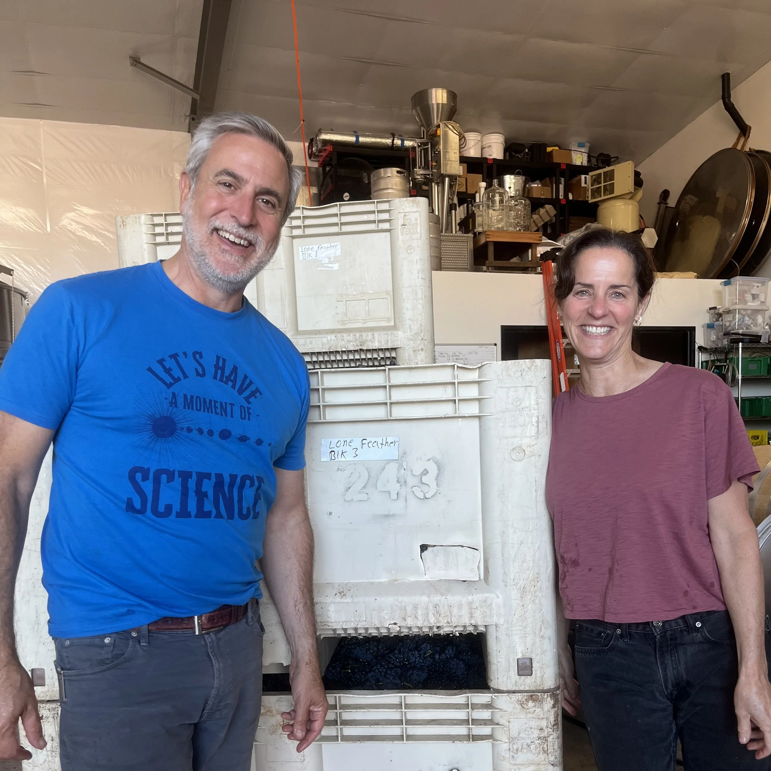 Warren and Jennifer Feather, the owners of Lone Feather Vineyard in the McMinnville AVA, standing in the Hundred Suns winery after processing fruit at harvest