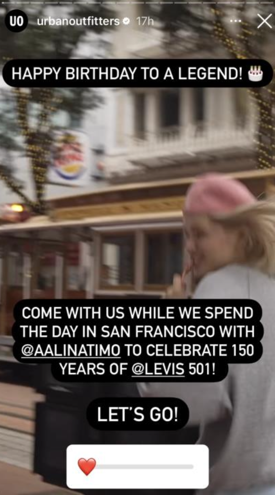 A blurry photo of a woman with blonde hair wearing a pink hat, standing outdoors in a city setting with buildings and string lights. Overlayed text celebrates a birthday, invites others to join in San Francisco, and references character celebrations from brands Levi's and Alina Timo.