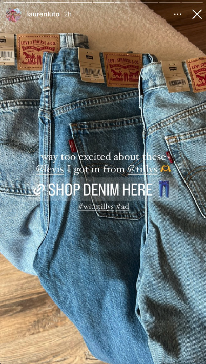 Three pairs of Levi's denim jeans displayed on a wooden floor, with visible Levi's tags and a palm tree emoji.