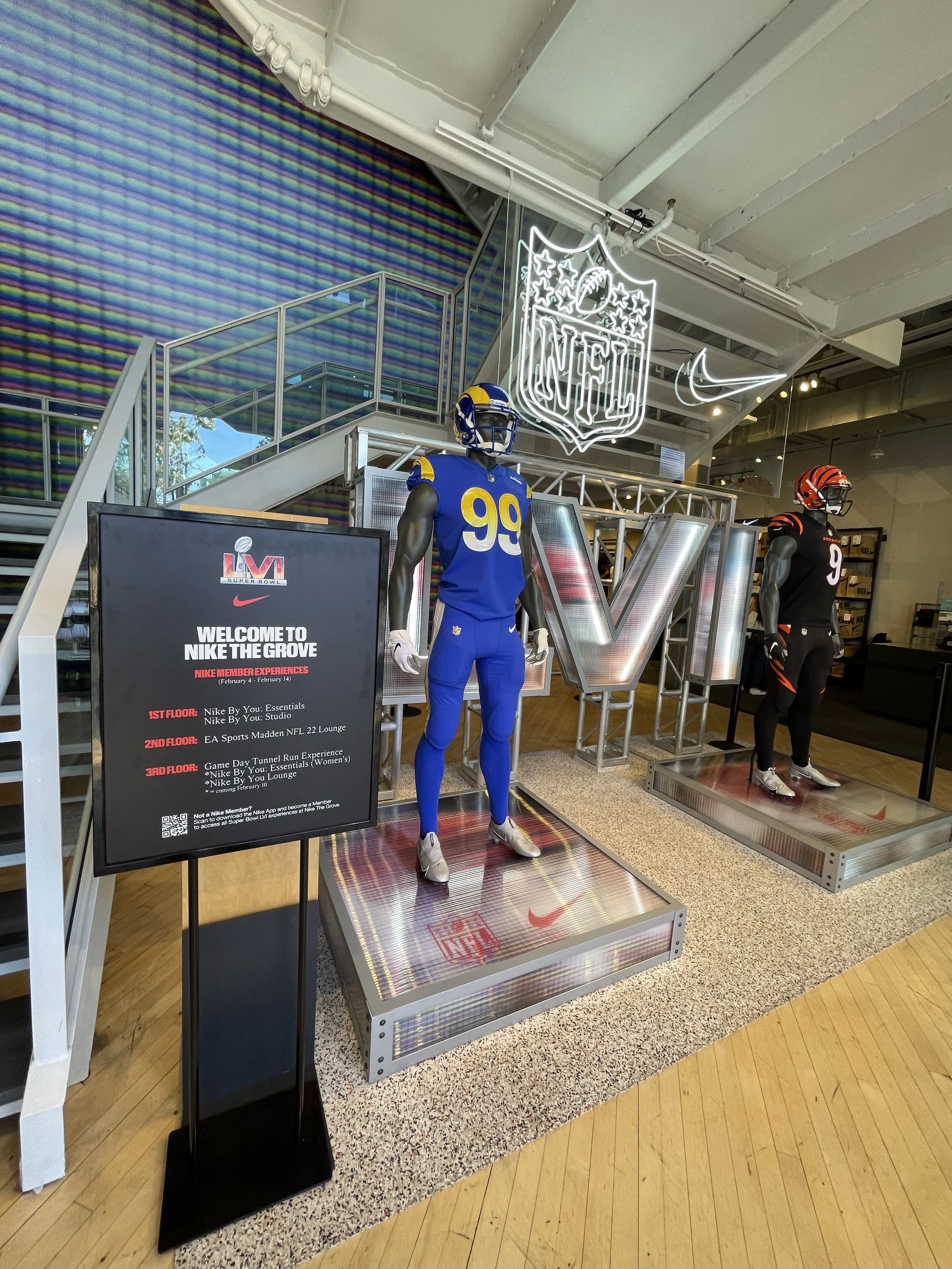 Display of NFL mannequins dressed in football uniforms at Nike store event, with NFL and Nike logos and event signage