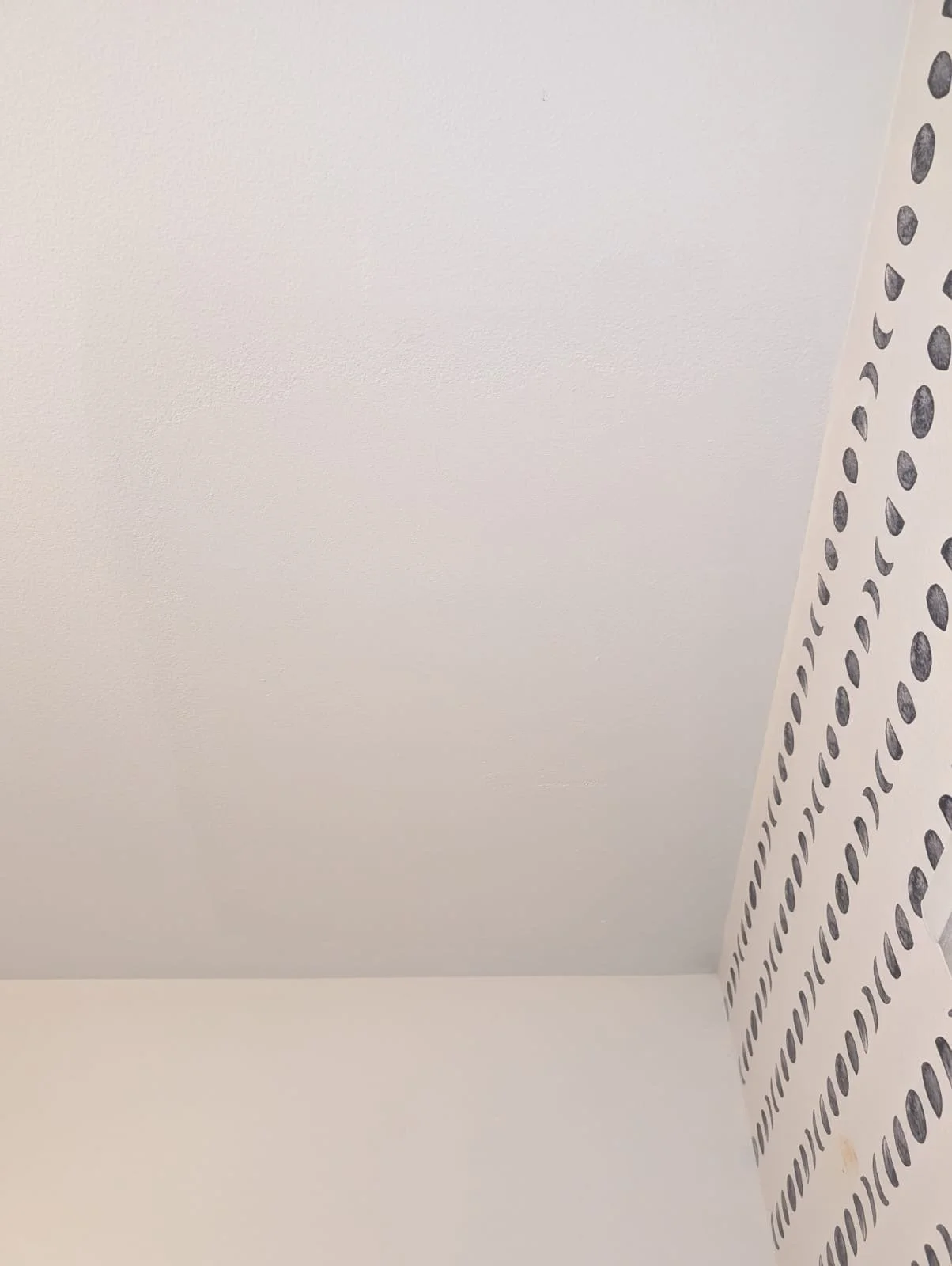 A corner of a room with plain white ceiling and wall.