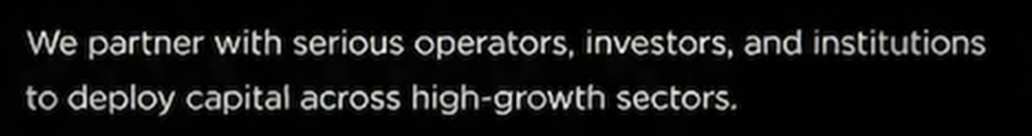 Close-up of a screen displaying the text: 'We partner with serious operators, investors, and institutions to deploy capital across high-growth sectors.'