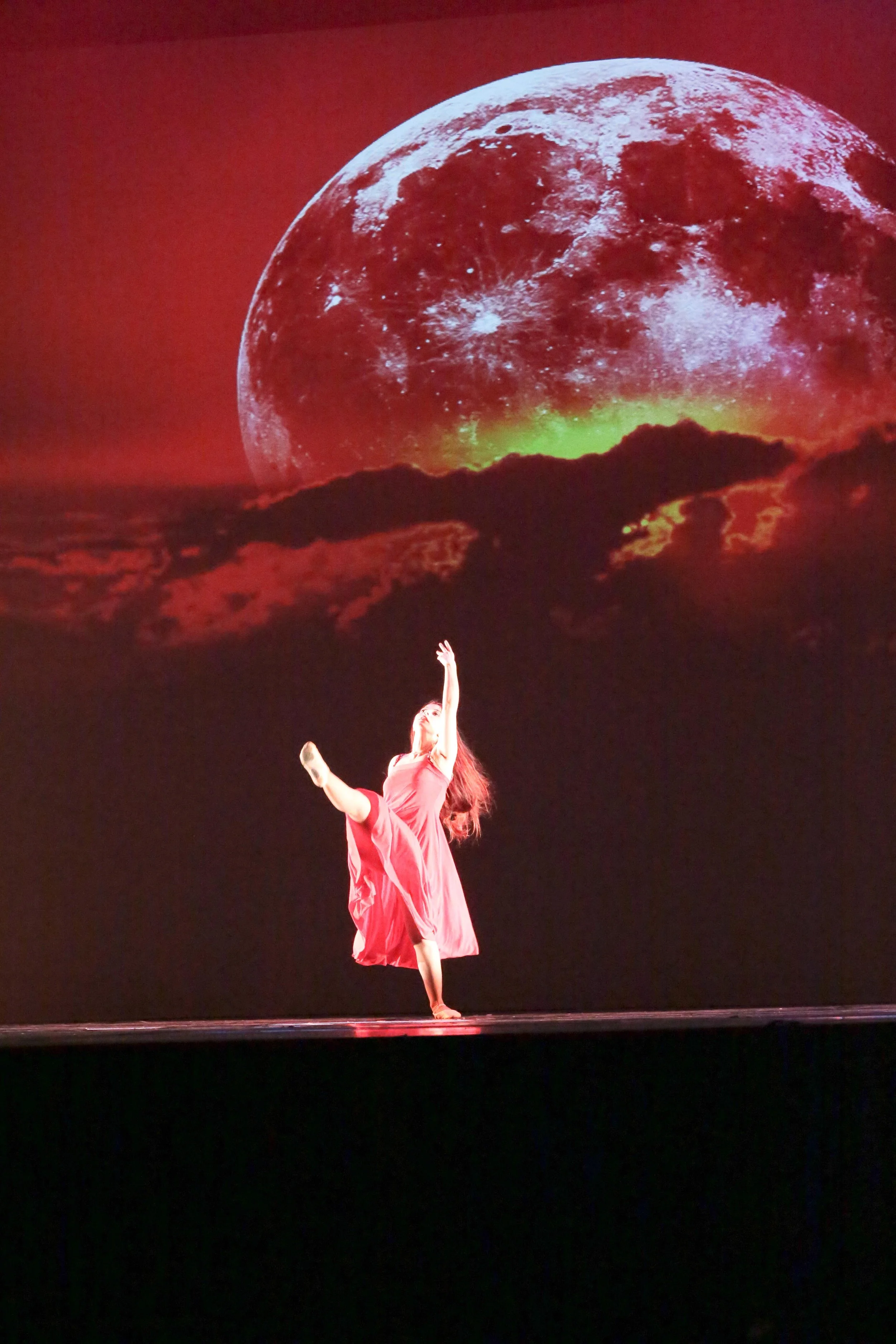 Danza con luna rossa sullo sfondo